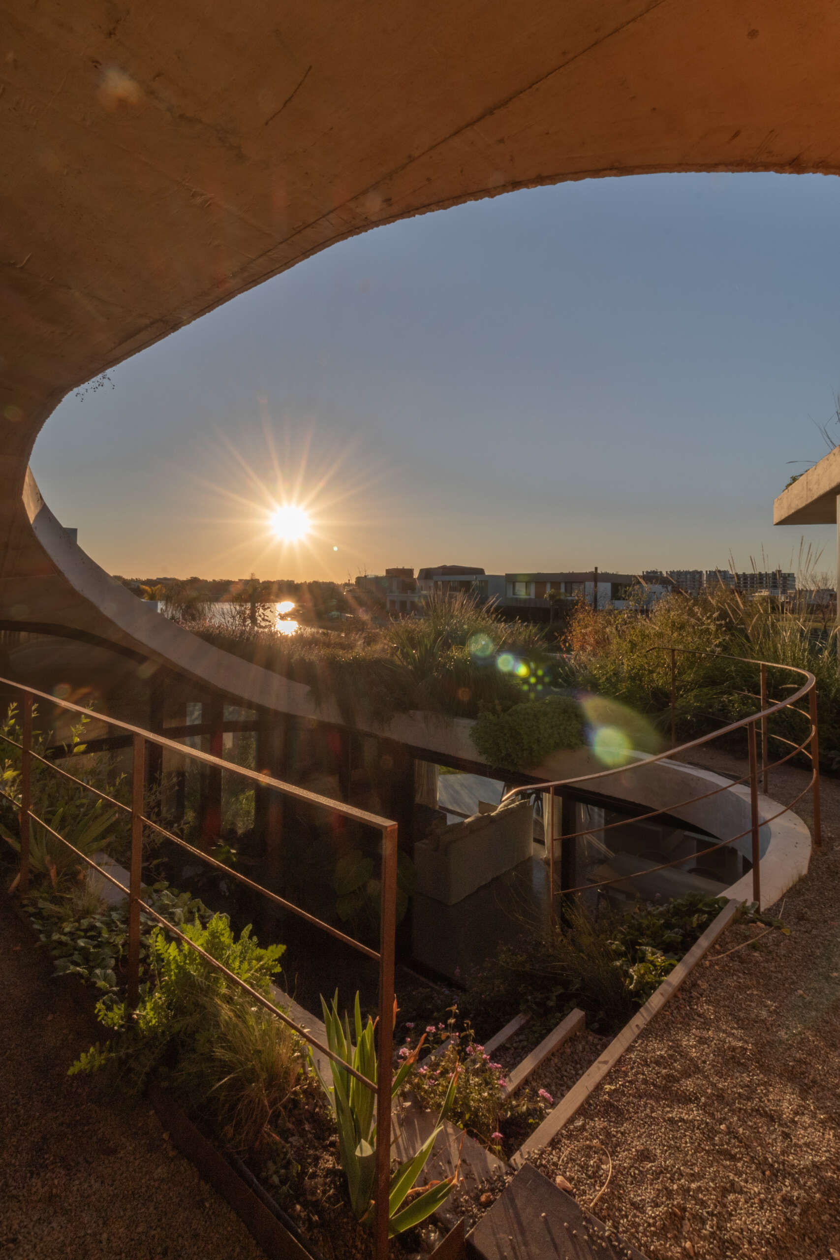 Discover how sliding doors and outdoor stairs connect the home's interiors with a lush rooftop garden overlooking the lagoon.