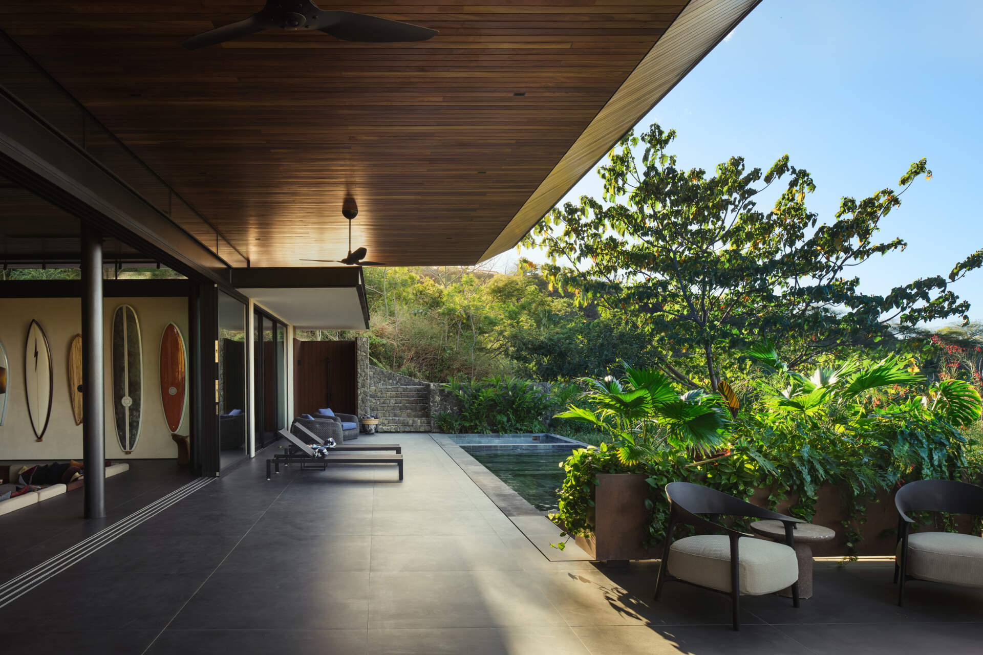 Discover the pool terrace where contemporary architecture, warm timber, and tropical planting come together in Costa Rica.