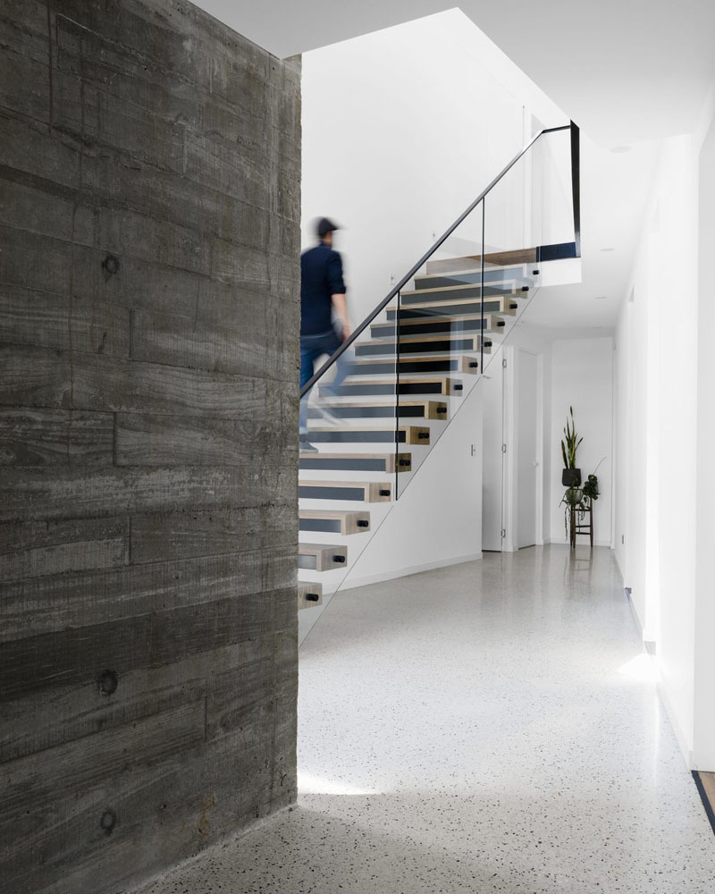 Las barandillas de vidrio y acero dan a esta escalera flotante un aspecto ligero y moderno al tiempo que conectan los distintos niveles de la casa.