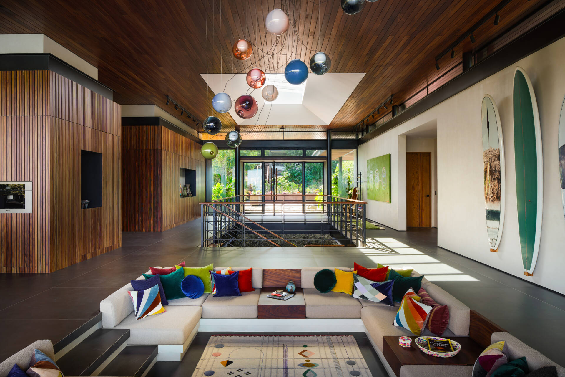 A sunken lounge, colourful accents, and skylights make this one of Casa Akíga's most inviting social spaces.