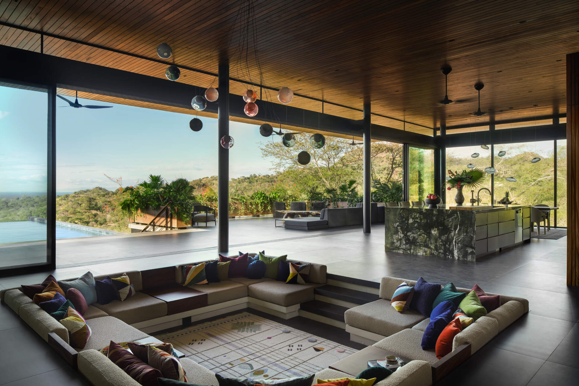 A sunken lounge, colourful accents, and skylights make this one of Casa Akíga's most inviting social spaces.
