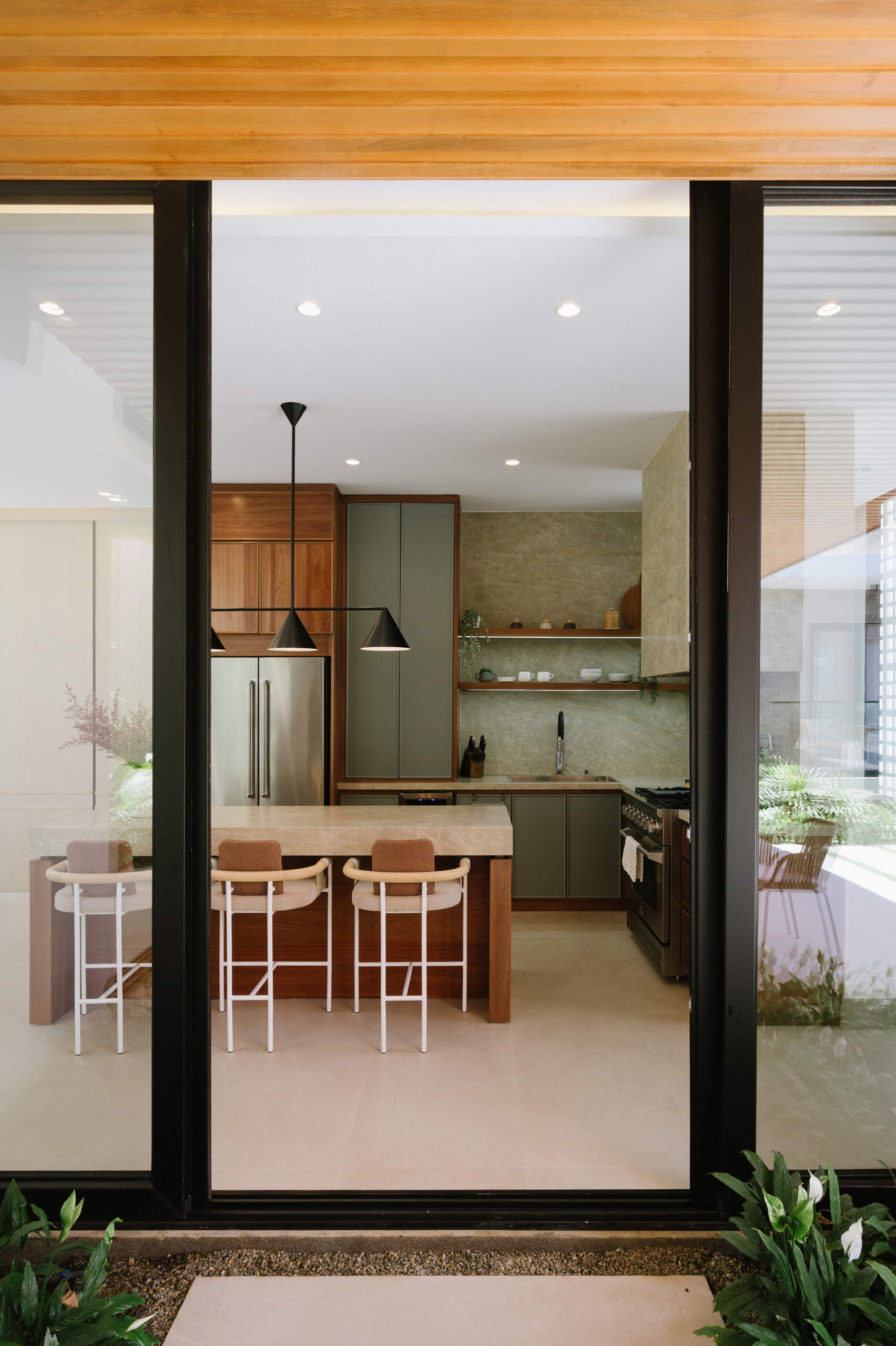 Explore an open-plan living room, dining area and kitchen filled with mountain views, natural stone, warm timber and floor-to-ceiling windows.