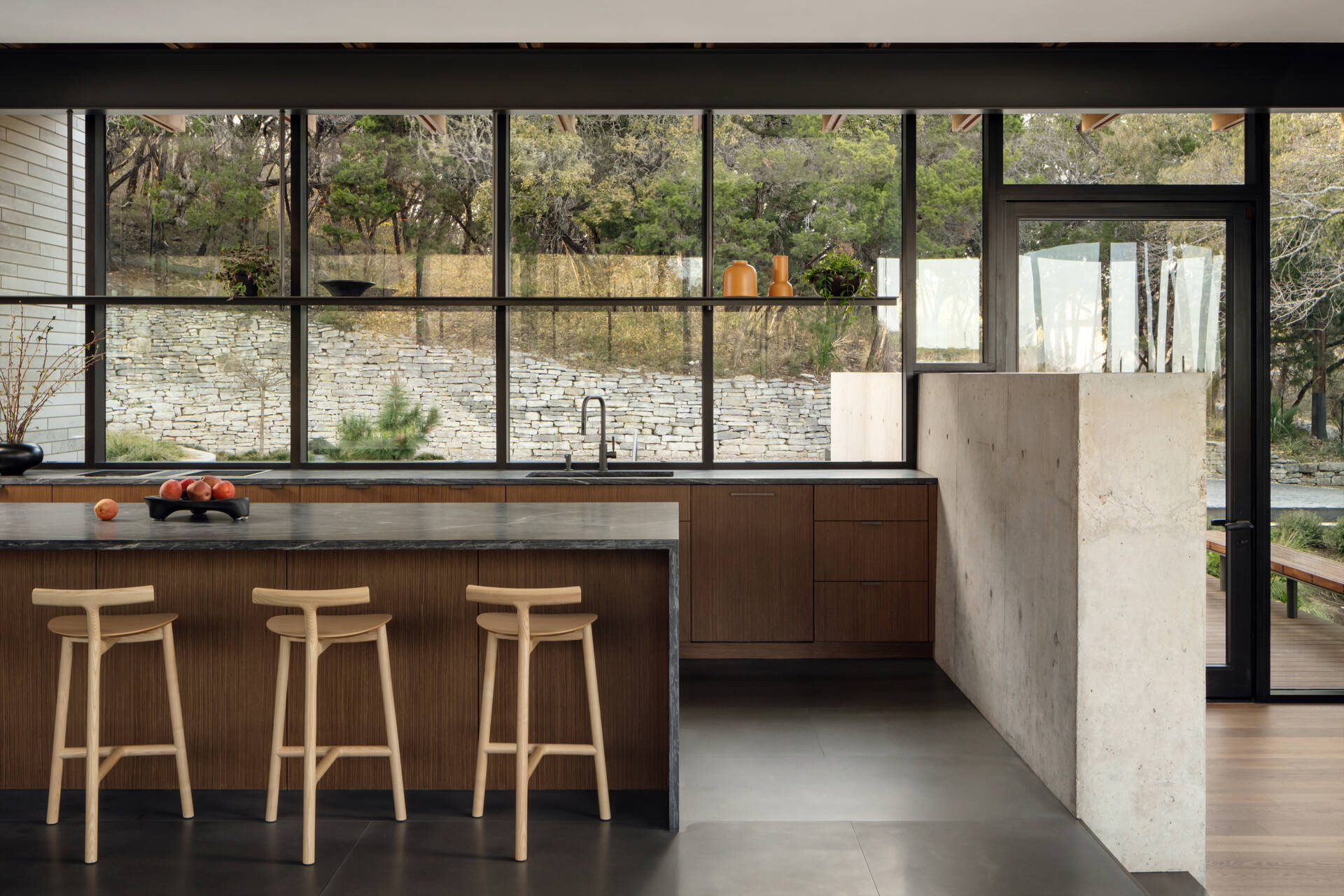 Warm walnut cabinetry and natural stone give this modern kitchen a timeless, welcoming feel.