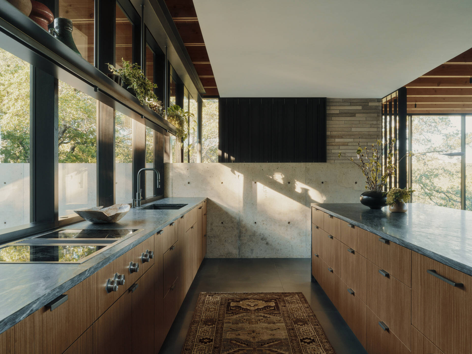 Warm walnut cabinetry and natural stone give this modern kitchen a timeless, welcoming feel.