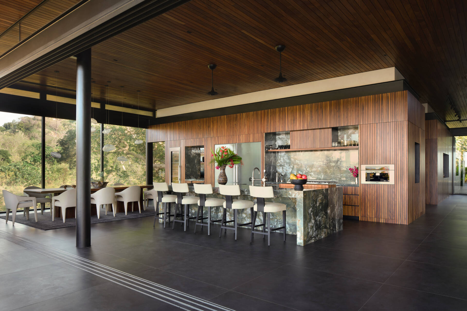 With a dramatic stone island, timber-lined ceilings, and open views, this kitchen is built for cooking and entertaining.