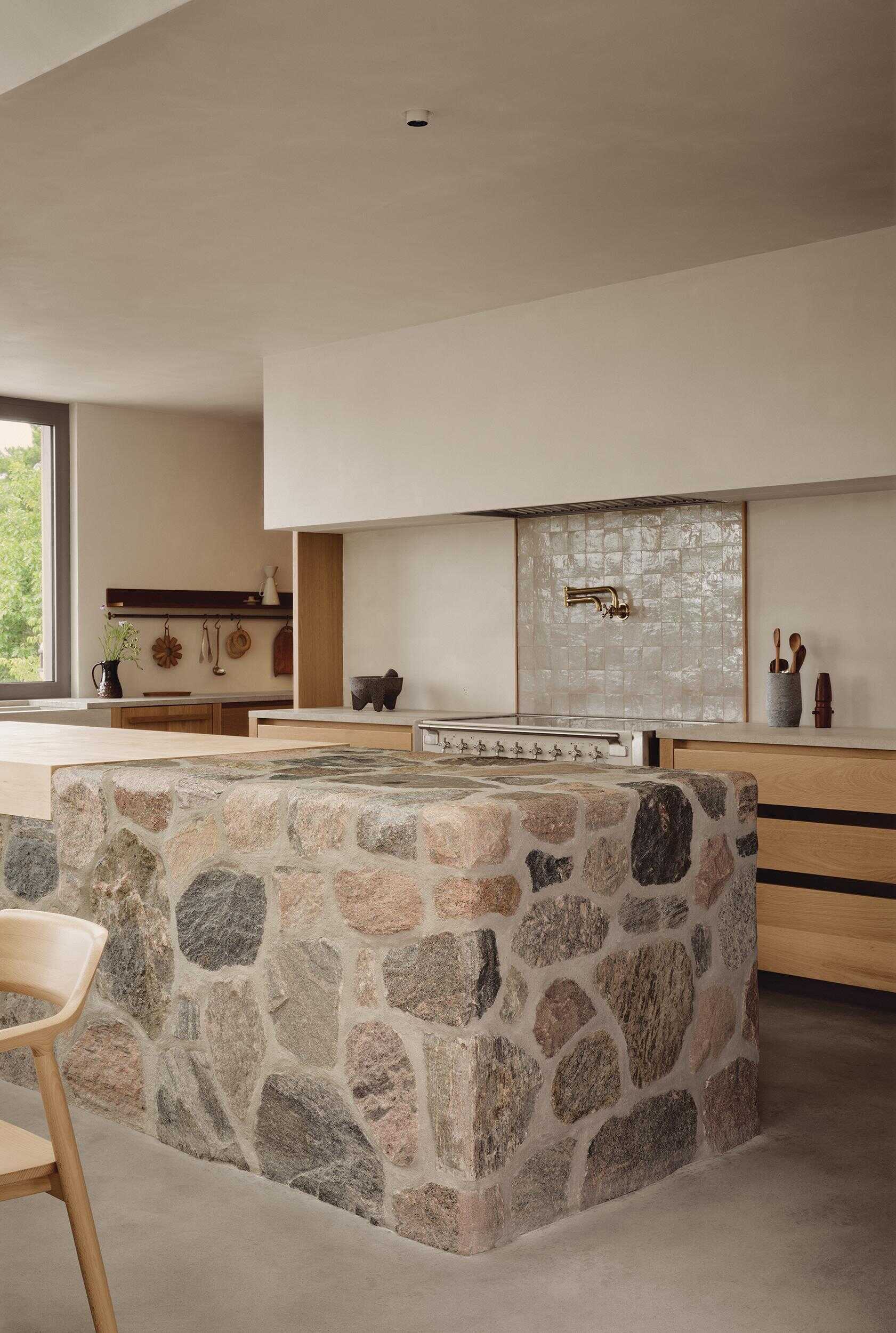 This beautiful kitchen features a fieldstone island, custom oak cabinetry and natural materials inspired by Georgian Bay.