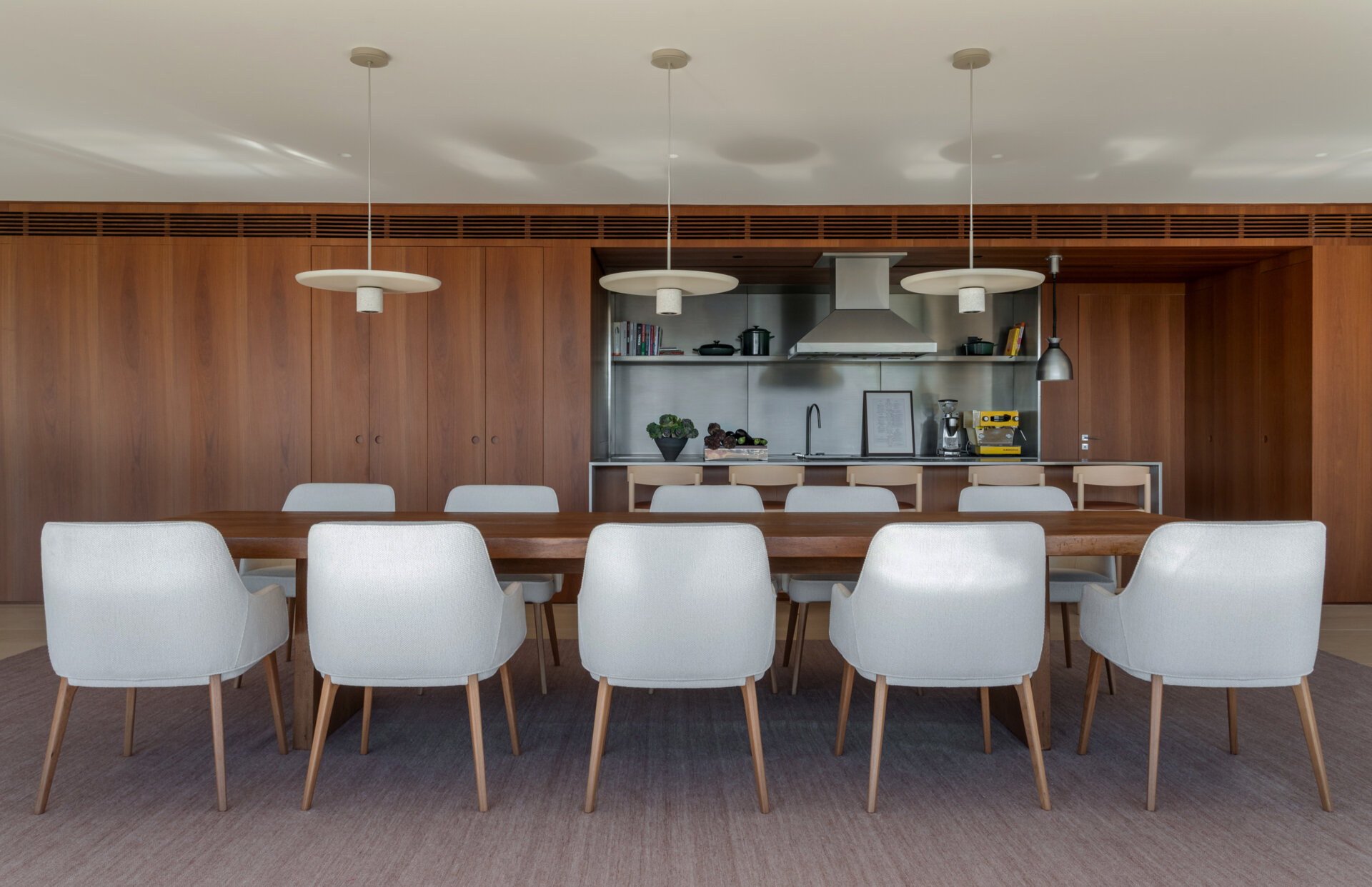 A solid timber dining table, designer lighting and artwork by Vik Muniz make this dining room simple, elegant and welcoming.