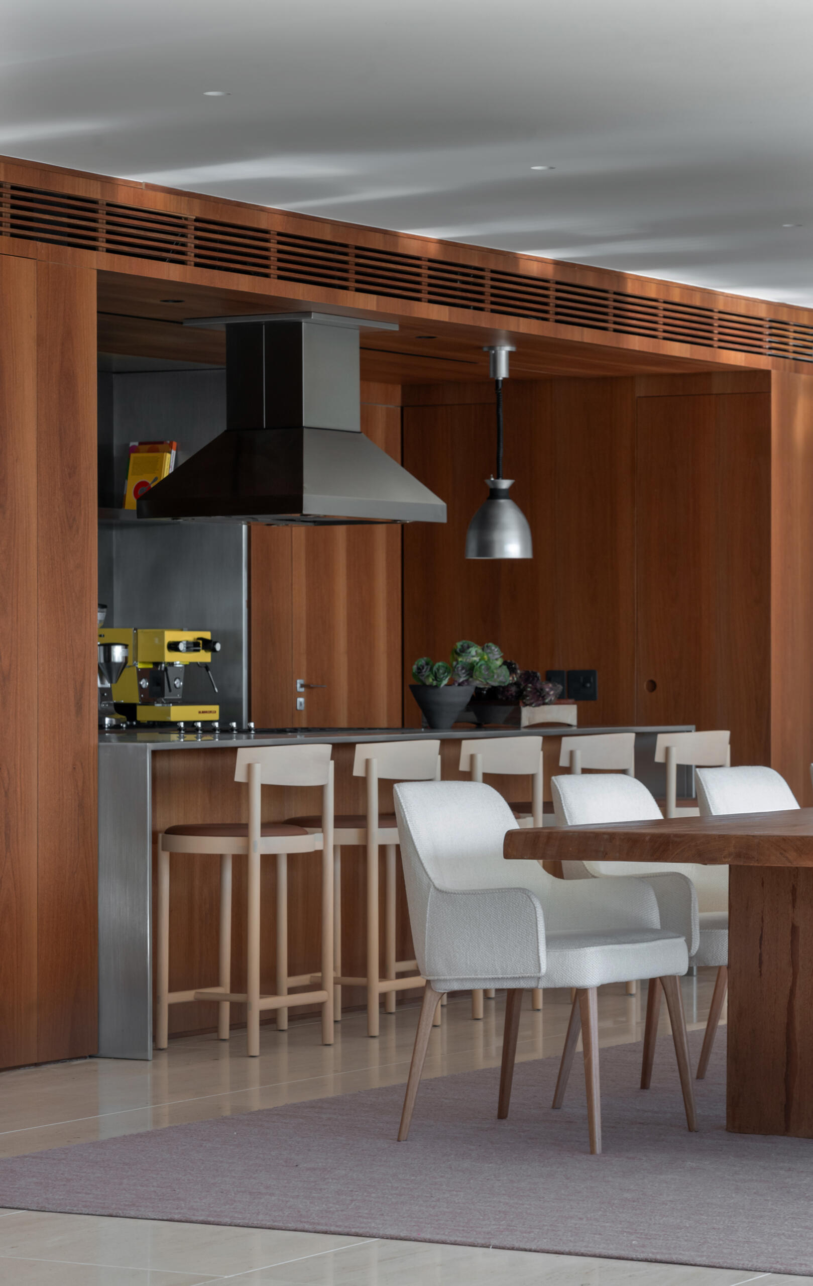 A solid timber dining table, designer lighting and artwork by Vik Muniz make this dining room simple, elegant and welcoming.