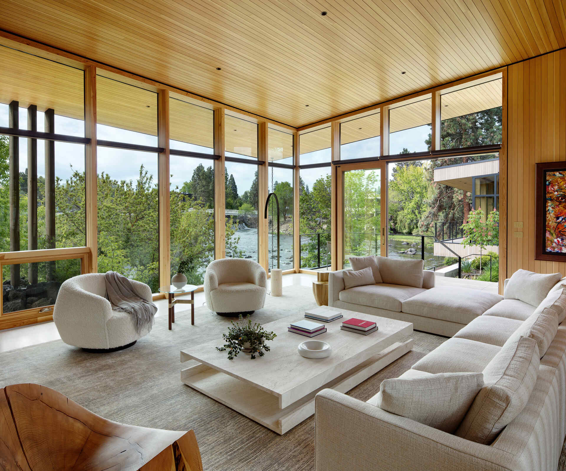 Ingrese al corazón de Riverfold House, donde los techos altos, las vistas al río, las chimeneas y los espacios interiores y exteriores integrados crean una sala de estar luminosa y acogedora.