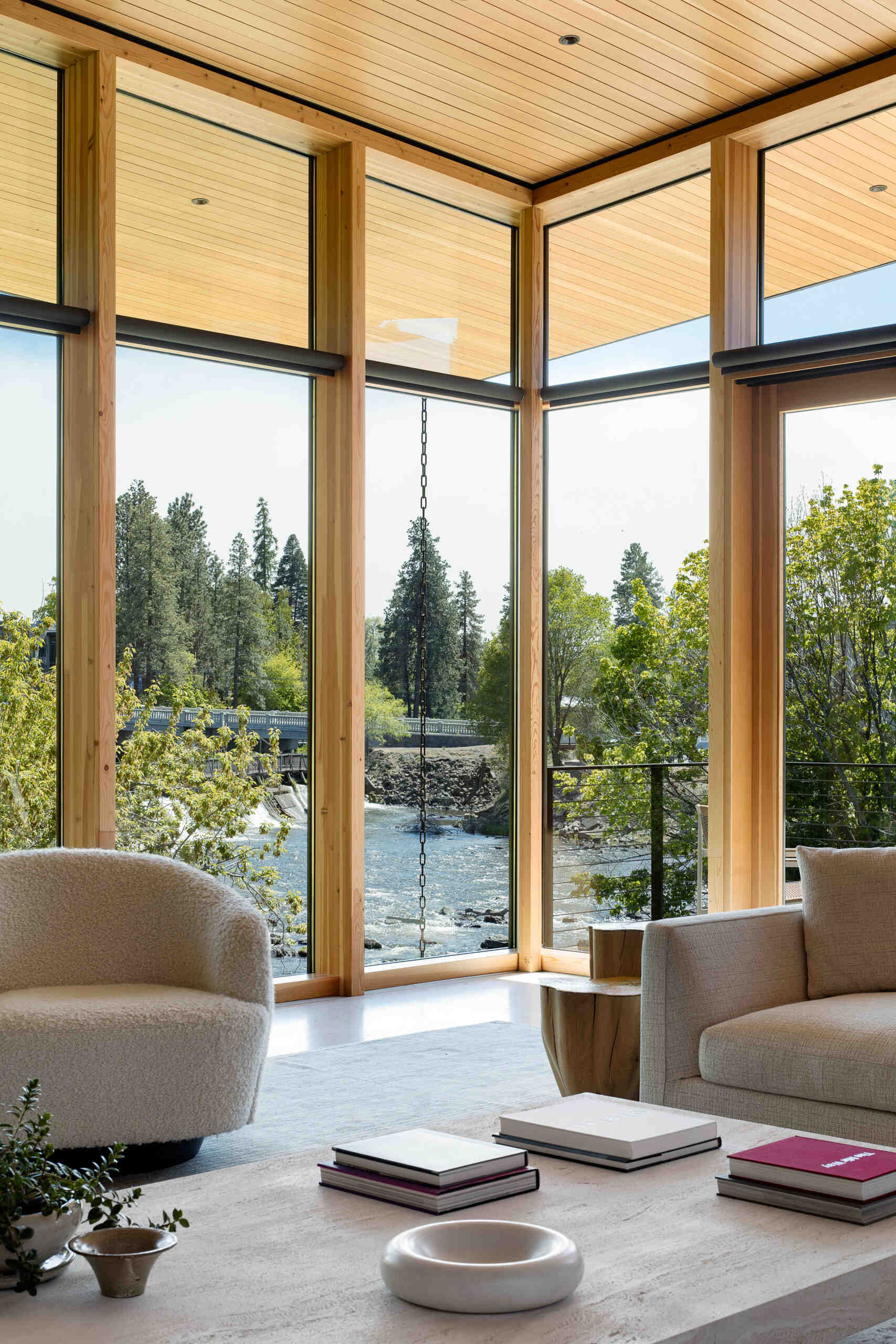 Ingrese al corazón de Riverfold House, donde los techos altos, las vistas al río, las chimeneas y los espacios interiores y exteriores integrados crean una sala de estar luminosa y acogedora.