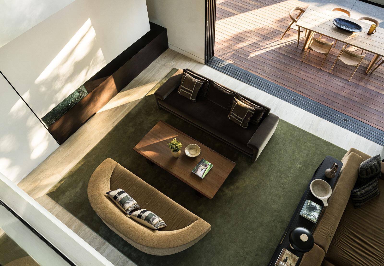 Step inside a bright double-height living room where floor-to-ceiling glazing frames a mature redwood tree, filling this modern Silicon Valley home with natural light and garden views.