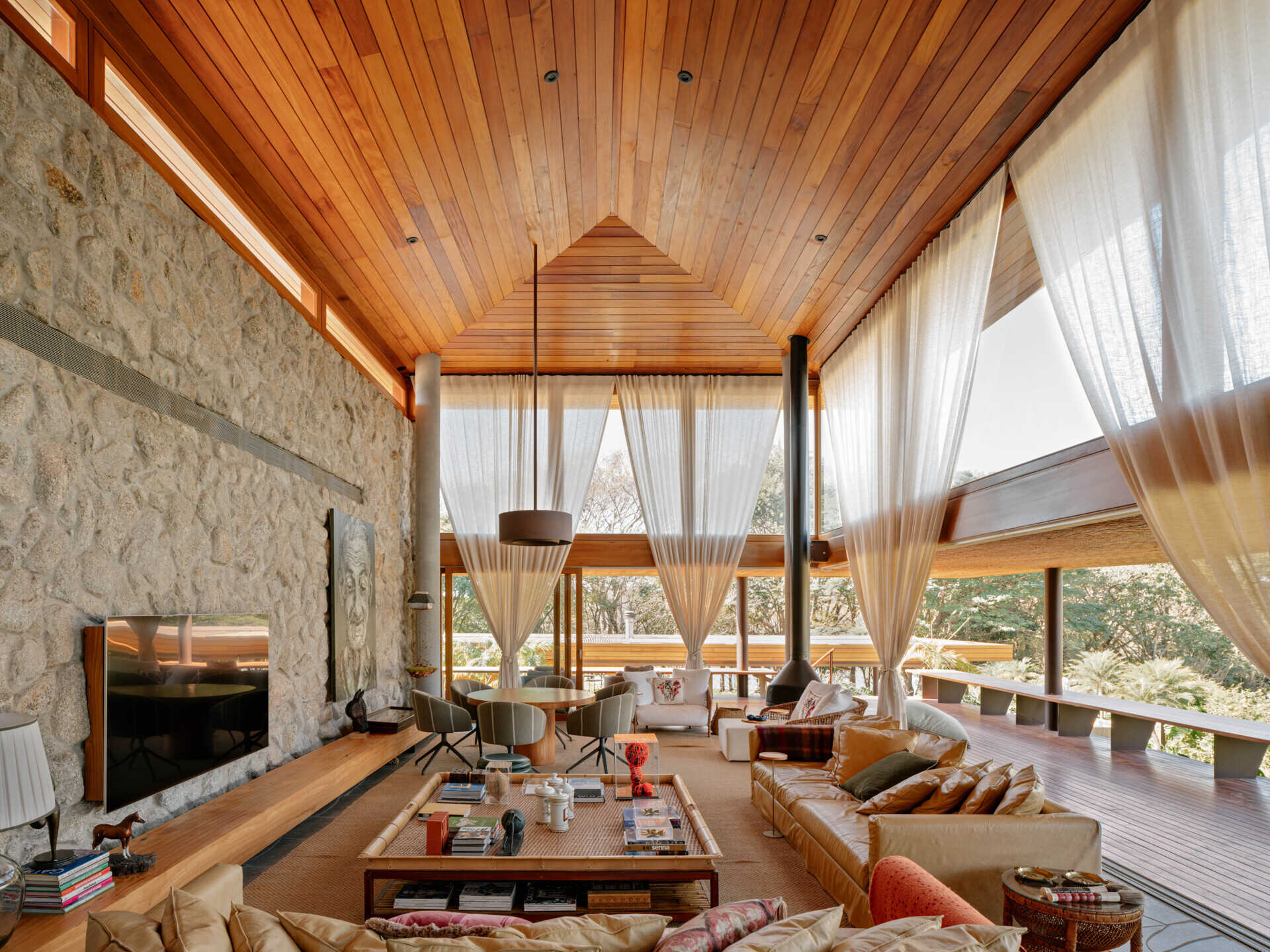 The living room forms one of the home's main gathering spaces, where neutral finishes allow natural materials to become the standout feature. A caramel leather sofa introduces warmth against the softer color palette, while decorative pieces add carefully chosen pops of color throughout the room.