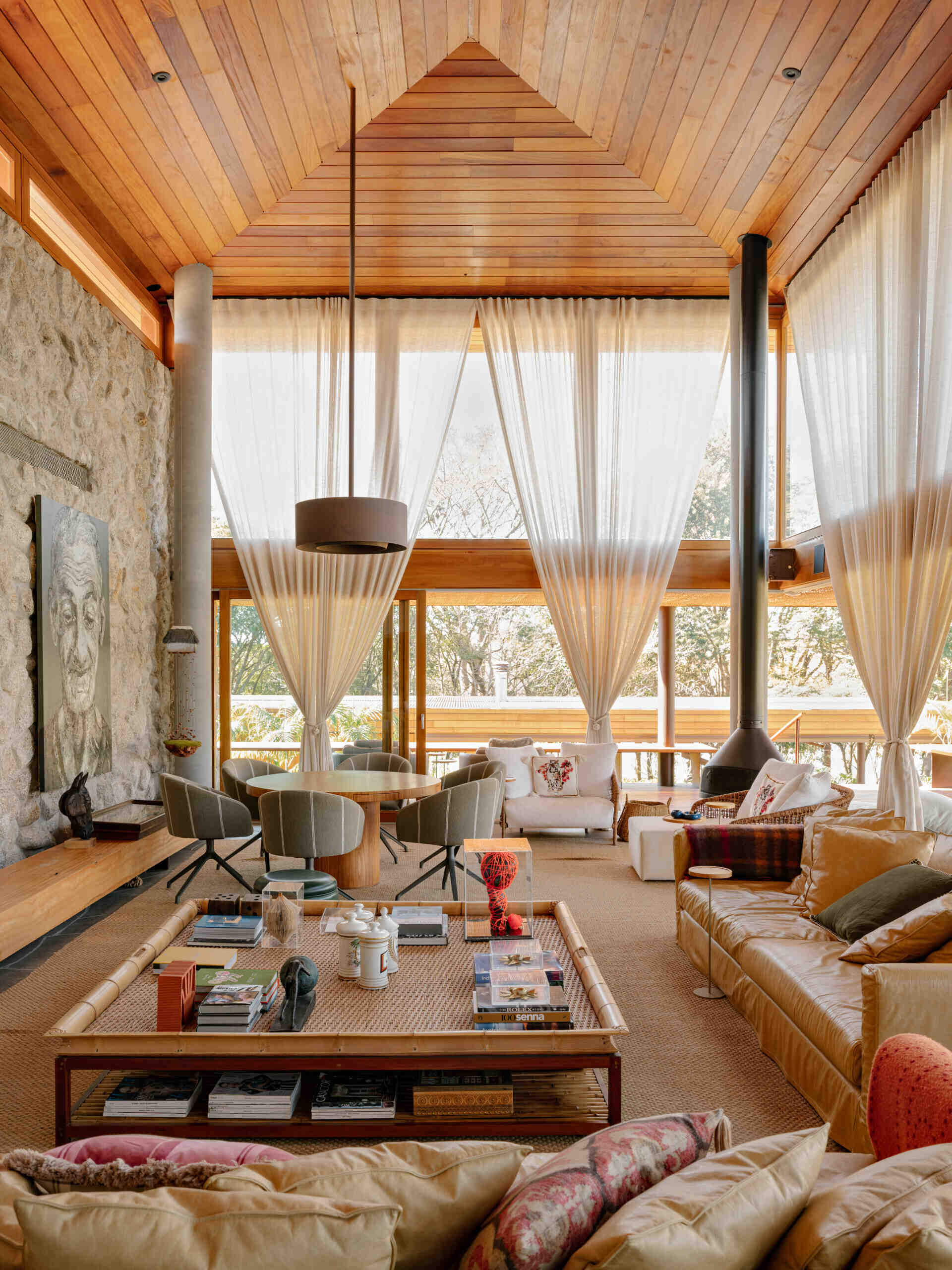 The living room forms one of the home's main gathering spaces, where neutral finishes allow natural materials to become the standout feature. A caramel leather sofa introduces warmth against the softer color palette, while decorative pieces add carefully chosen pops of color throughout the room.