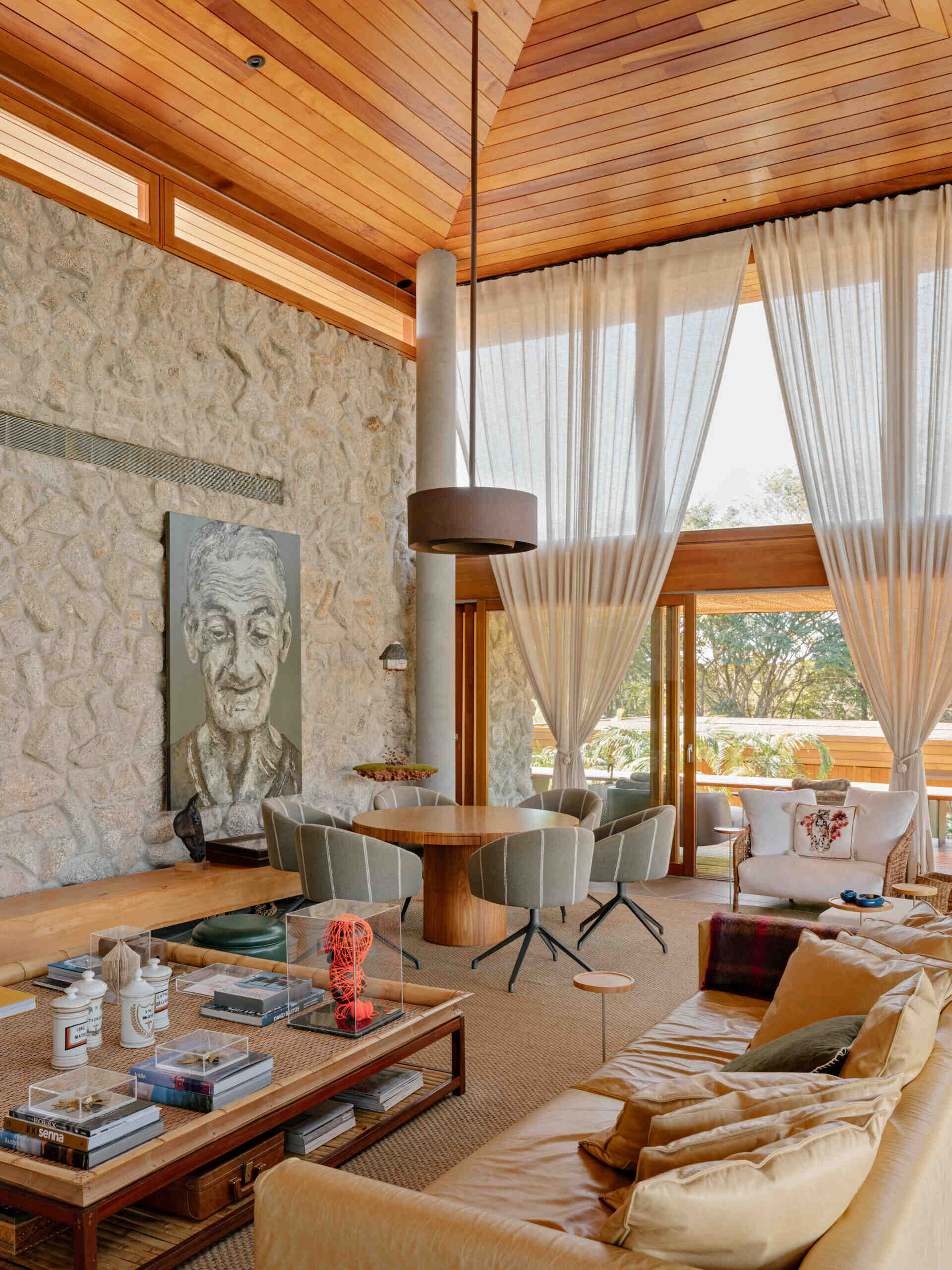 The living room forms one of the home's main gathering spaces, where neutral finishes allow natural materials to become the standout feature. A caramel leather sofa introduces warmth against the softer color palette, while decorative pieces add carefully chosen pops of color throughout the room.