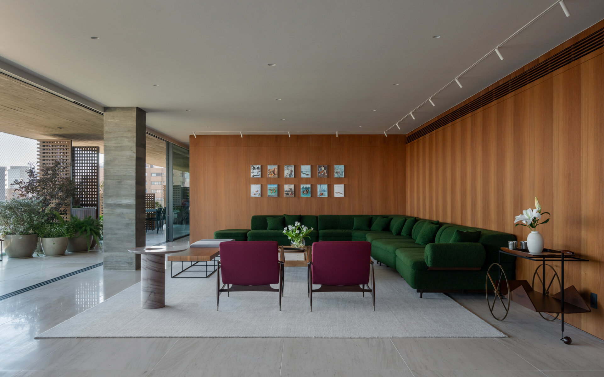 This living room combines iconic Brazilian furniture, limestone floors and expansive city views for a warm, inviting entertaining space.