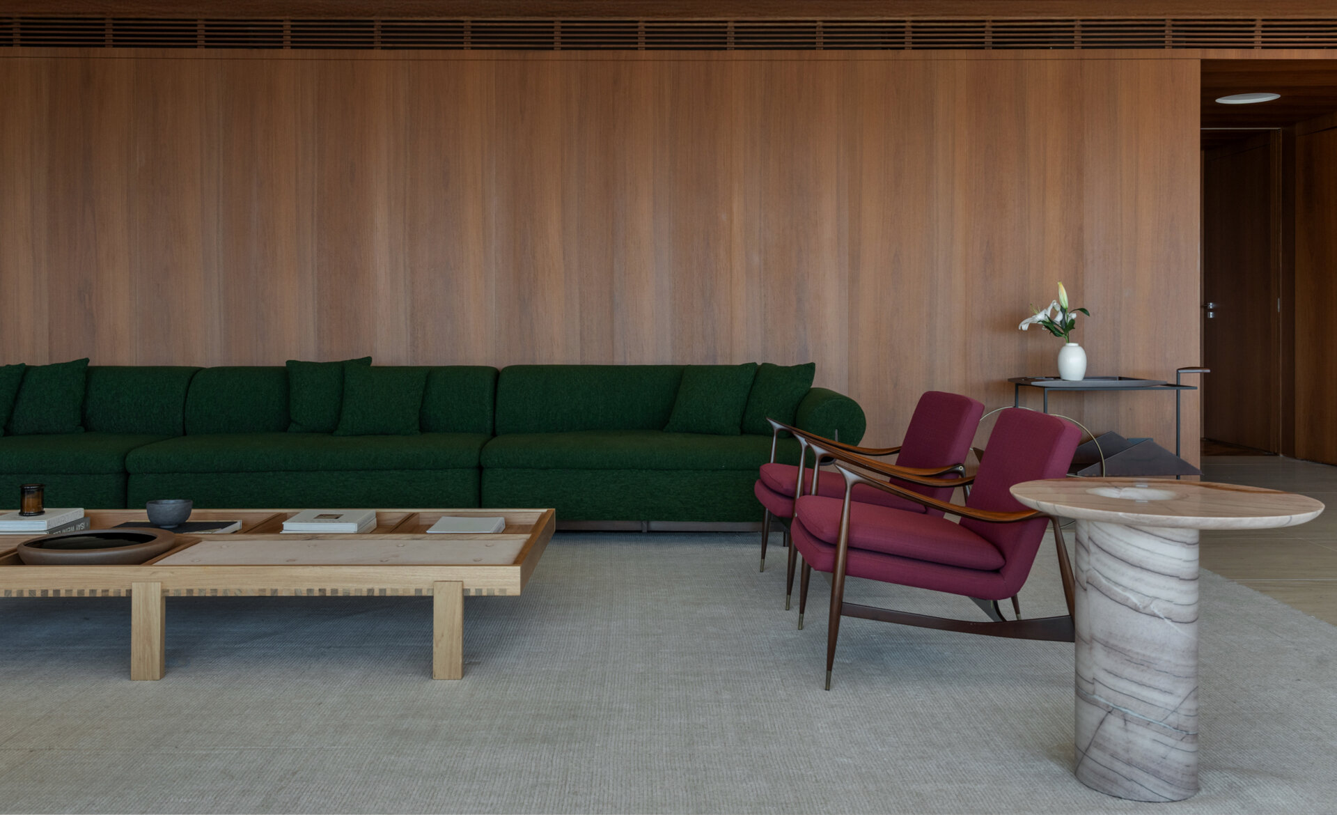 This living room combines iconic Brazilian furniture, limestone floors and expansive city views for a warm, inviting entertaining space.