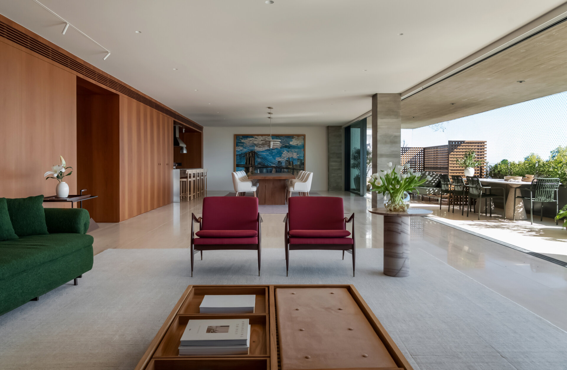 This living room combines iconic Brazilian furniture, limestone floors and expansive city views for a warm, inviting entertaining space.