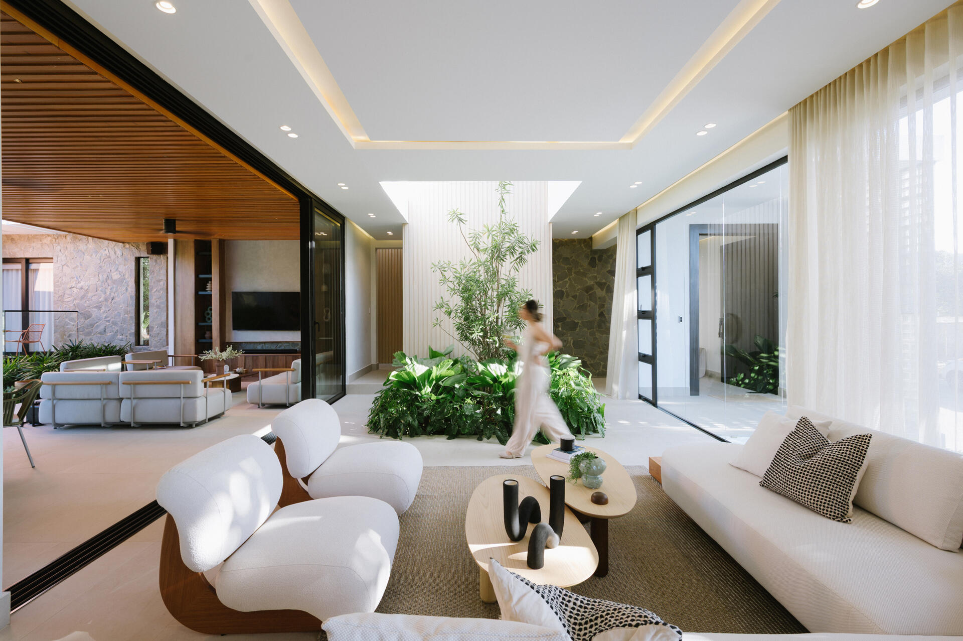 Explore an open-plan living room, dining area and kitchen filled with mountain views, natural stone, warm timber and floor-to-ceiling windows.