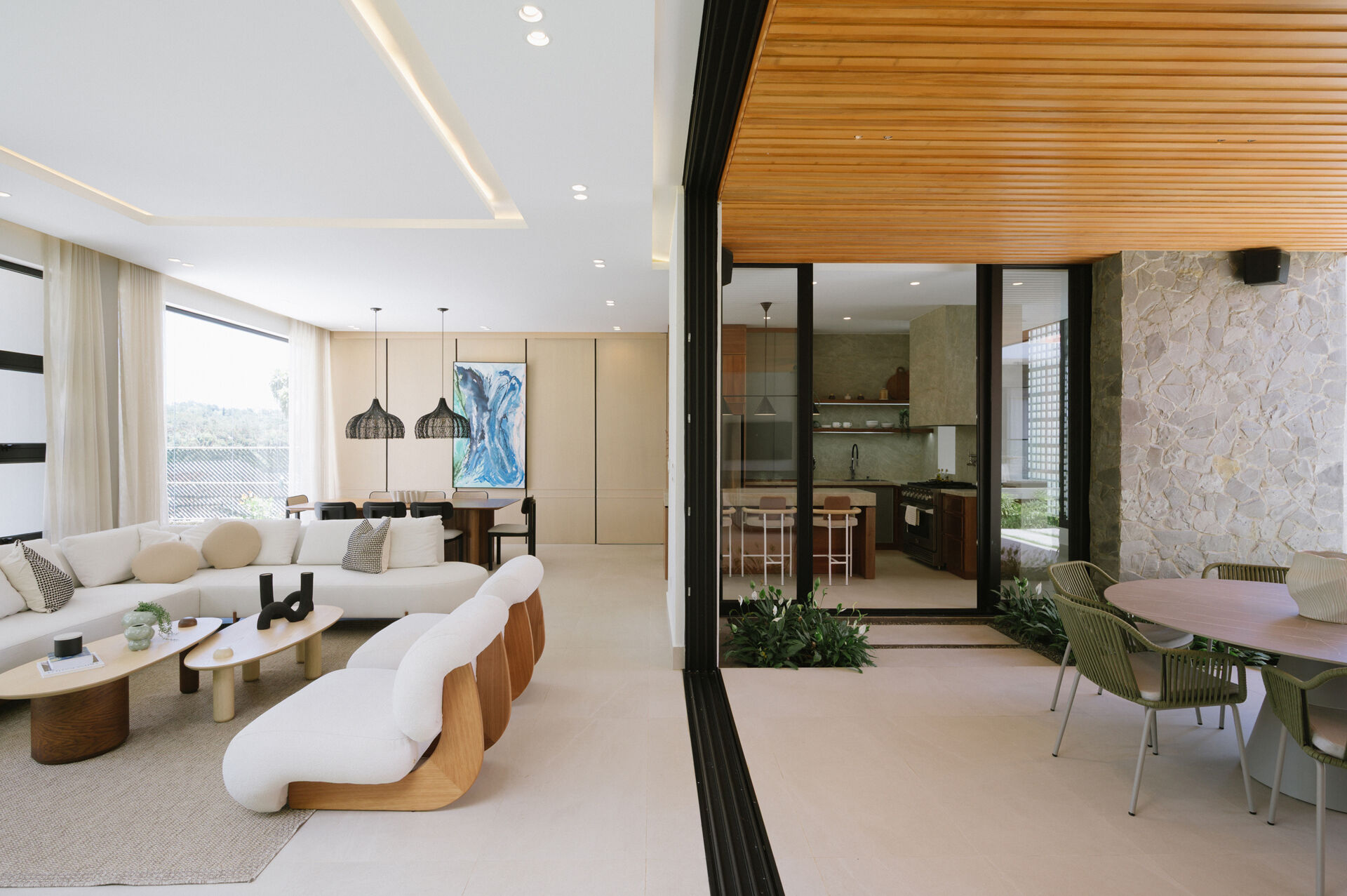 Explore an open-plan living room, dining area and kitchen filled with mountain views, natural stone, warm timber and floor-to-ceiling windows.