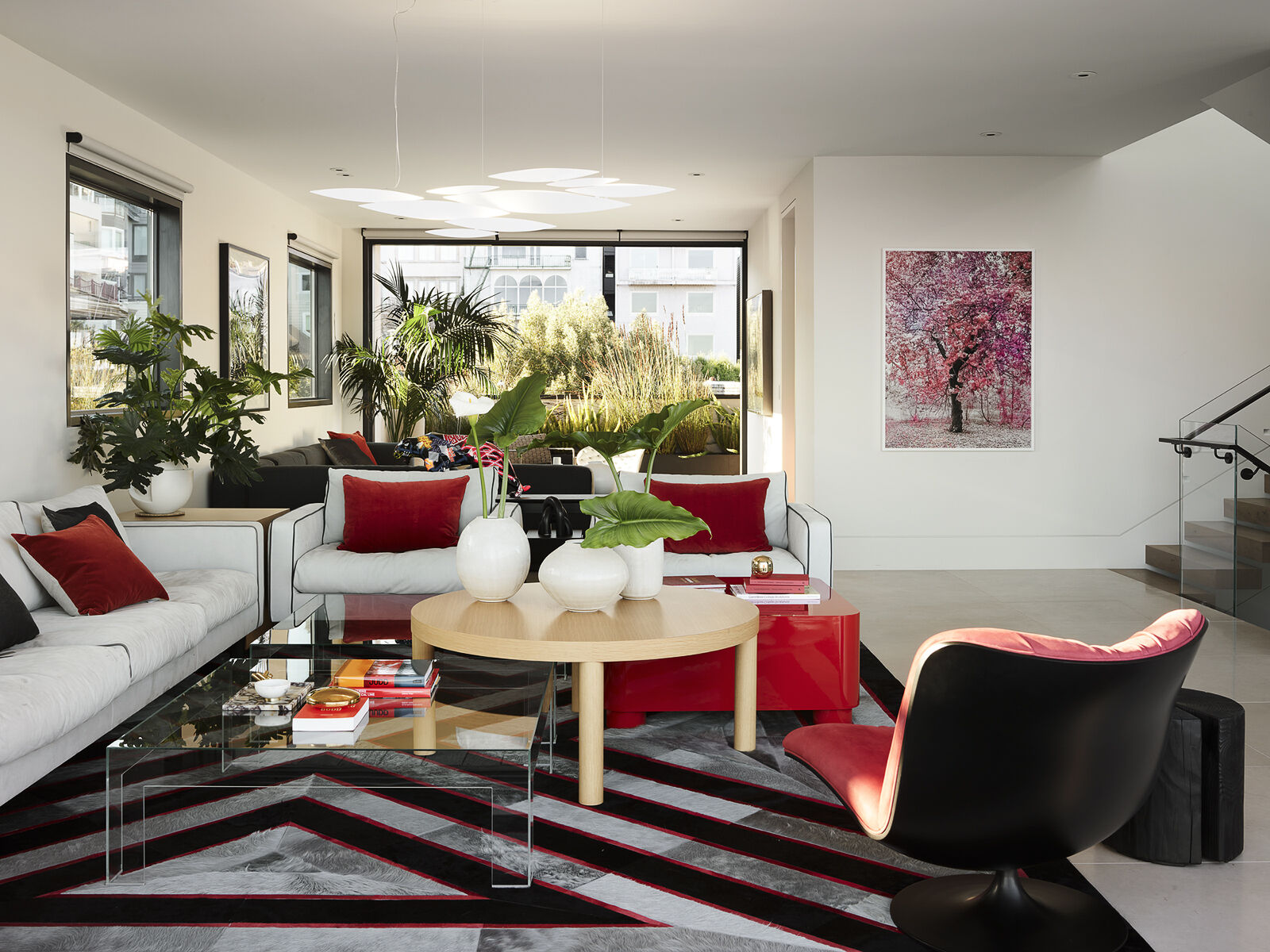 Floor-to-ceiling glass, water views, and bold accents make this contemporary living room feel bright from morning to night. See how layered textures and sculptural lighting create a space that's equally suited to relaxing and entertaining.
