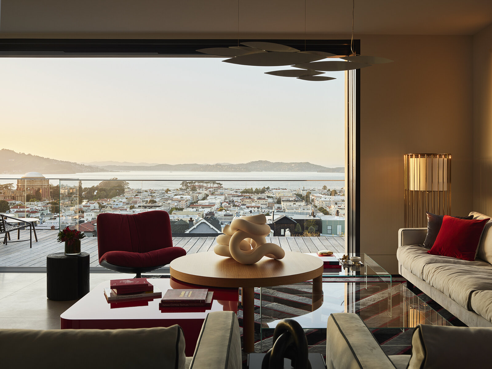 Floor-to-ceiling glass, water views, and bold accents make this contemporary living room feel bright from morning to night. See how layered textures and sculptural lighting create a space that's equally suited to relaxing and entertaining.