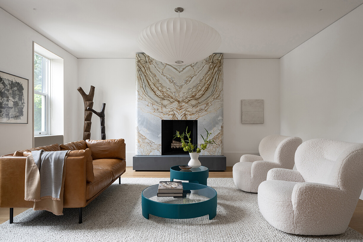 Discover the restored living room with its curved marble fireplace, contemporary furnishings, and modern lighting inside Snider House.