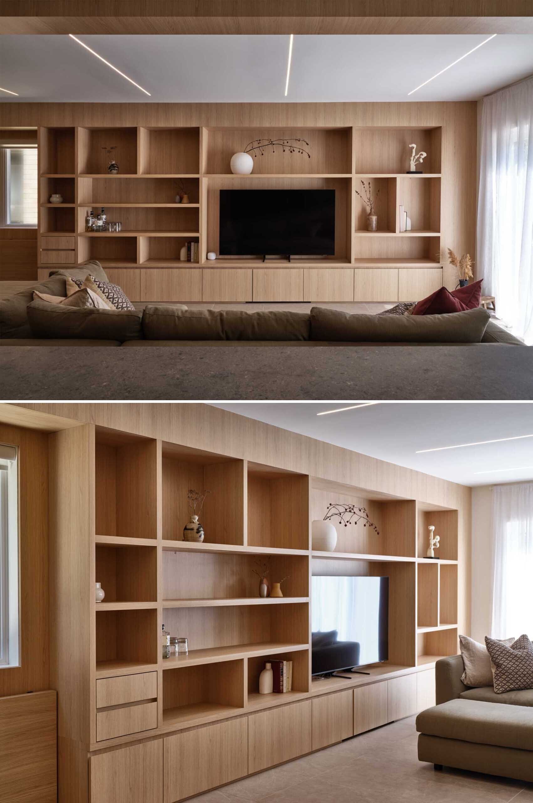 See how custom wood cabinetry transforms this open living room with hidden storage, integrated workspaces, and a sculptural feature that makes structural columns almost disappear.
