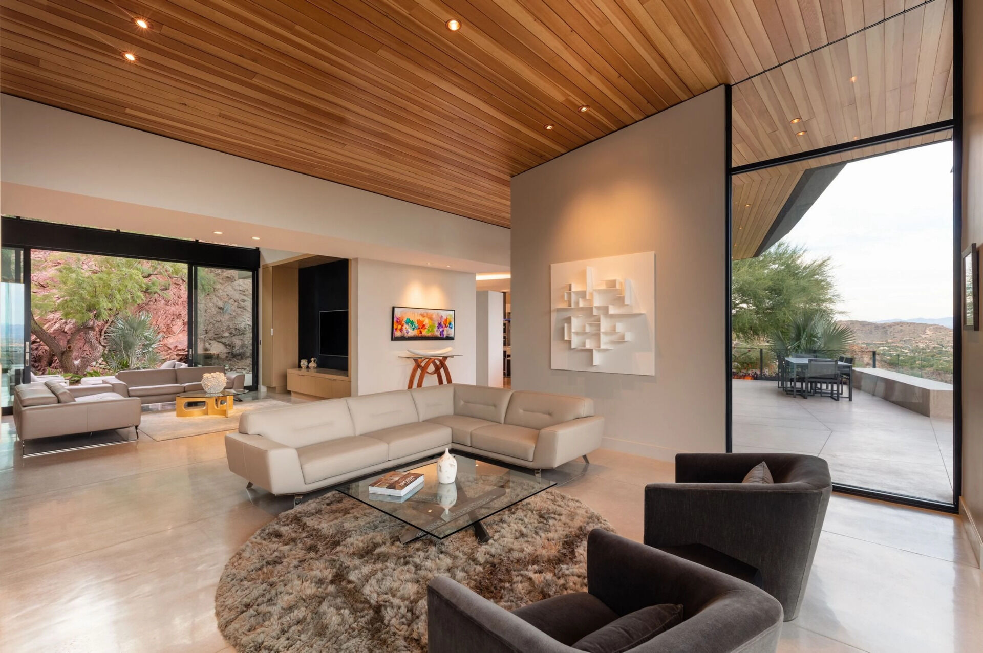 Explore a cozy second lounge with a fireplace and sliding glass walls that open directly onto the landscape.