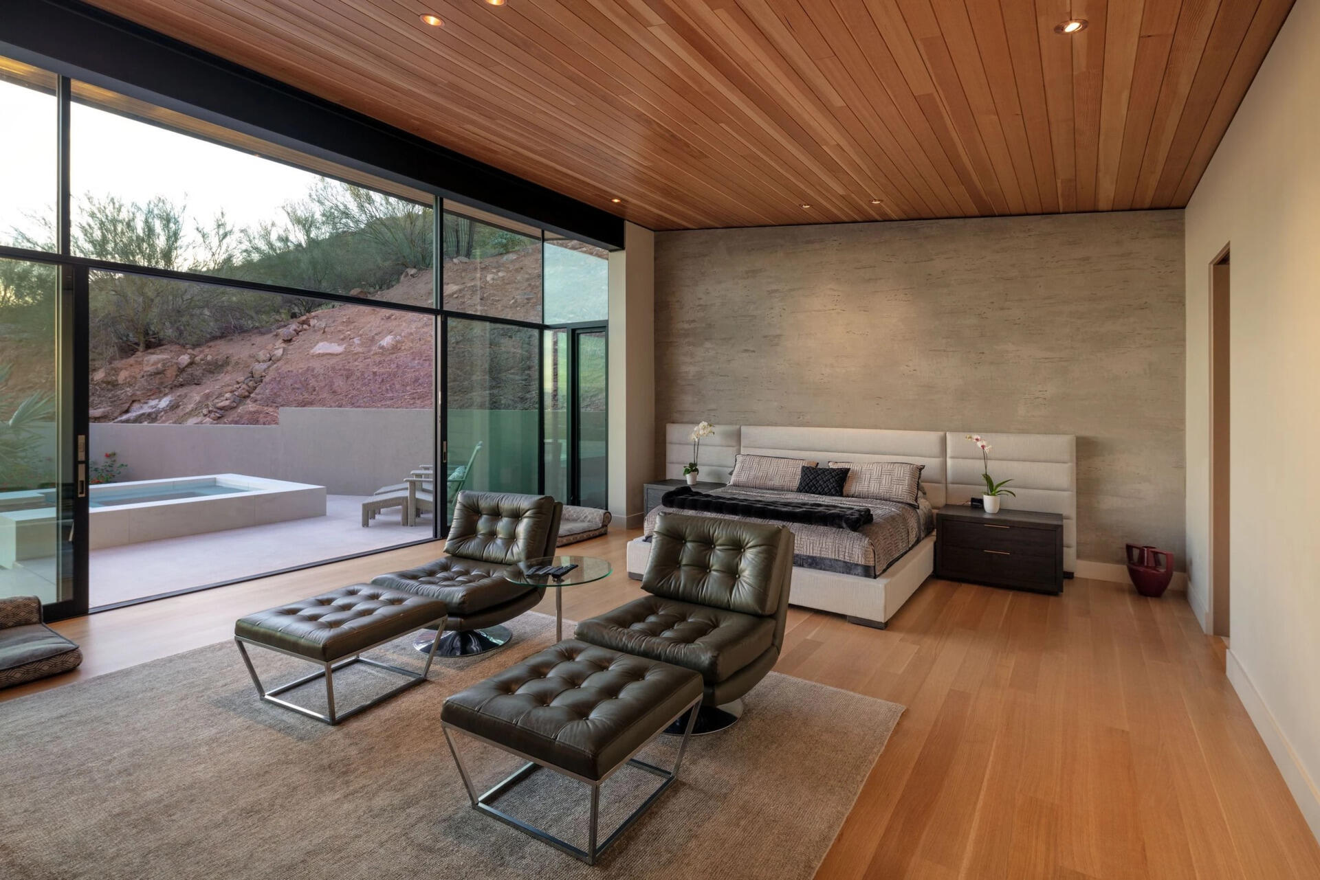A warm timber bedroom, fireplace lounge, and peaceful home office showcase the quieter side of this Arizona home.