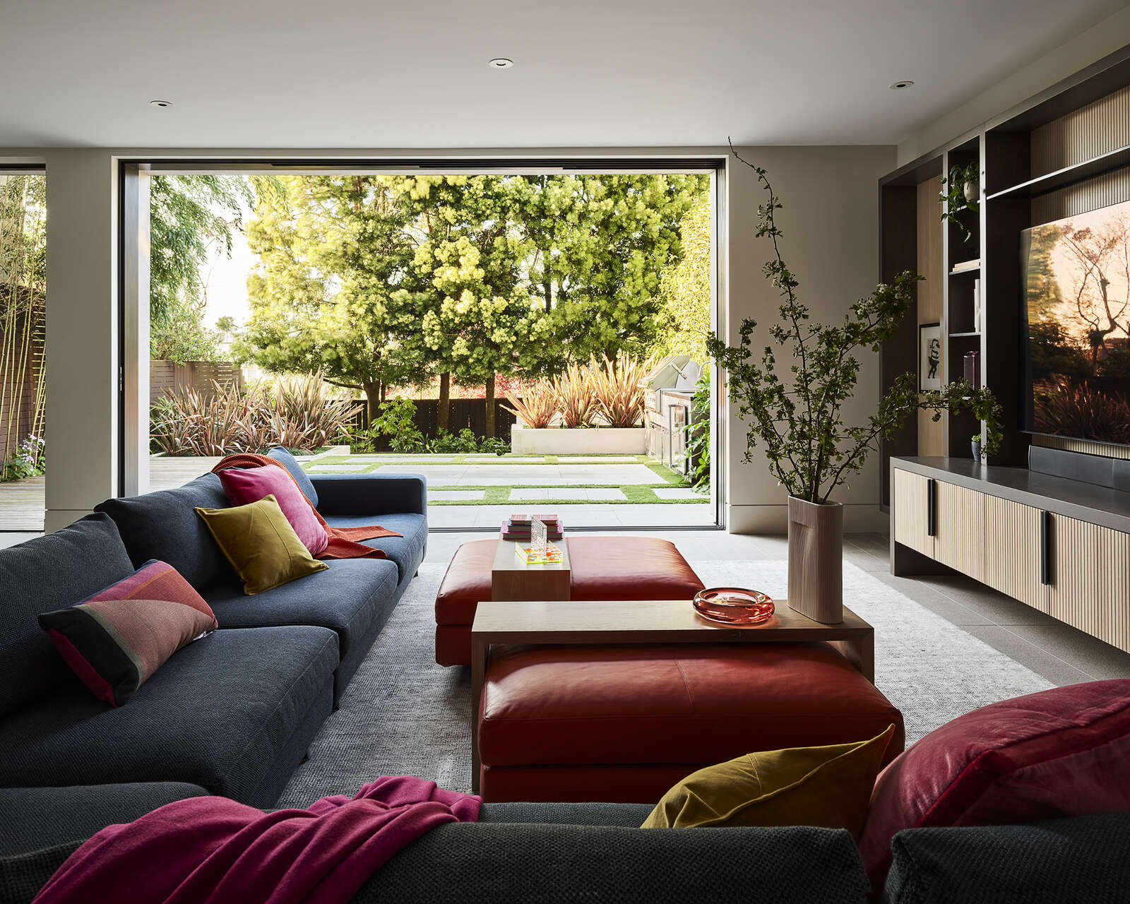 This colorful family room opens directly onto the garden, creating an effortless connection between indoor comfort and outdoor living. Discover how rich colors, custom cabinetry, and natural light shape the space.