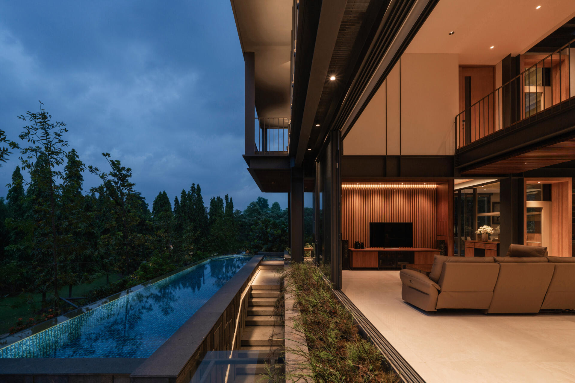 A covered outdoor living area and front swimming pool blur the line between indoor comfort and tropical outdoor living.