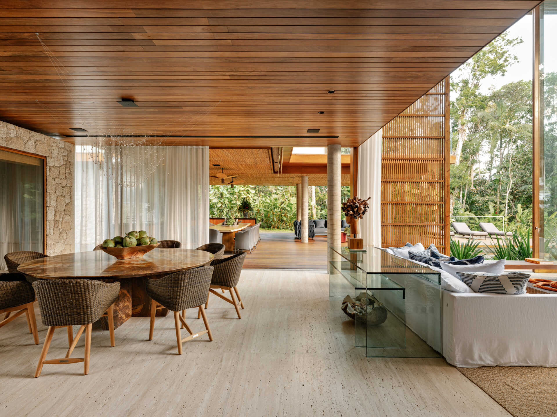 A custom stone dining table and sculptural lighting elevate this elegant coastal dining room.