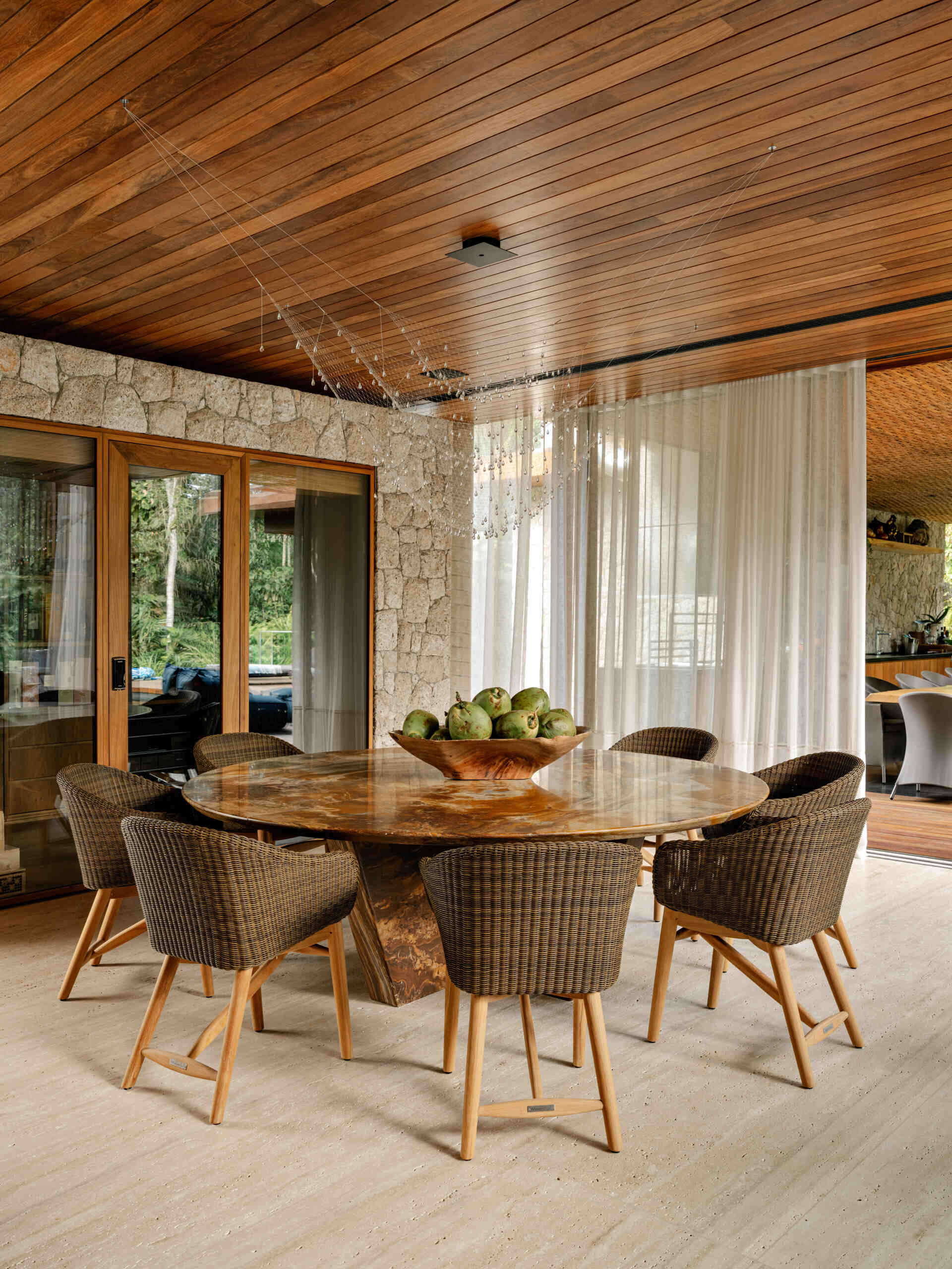 A custom stone dining table and sculptural lighting elevate this elegant coastal dining room.