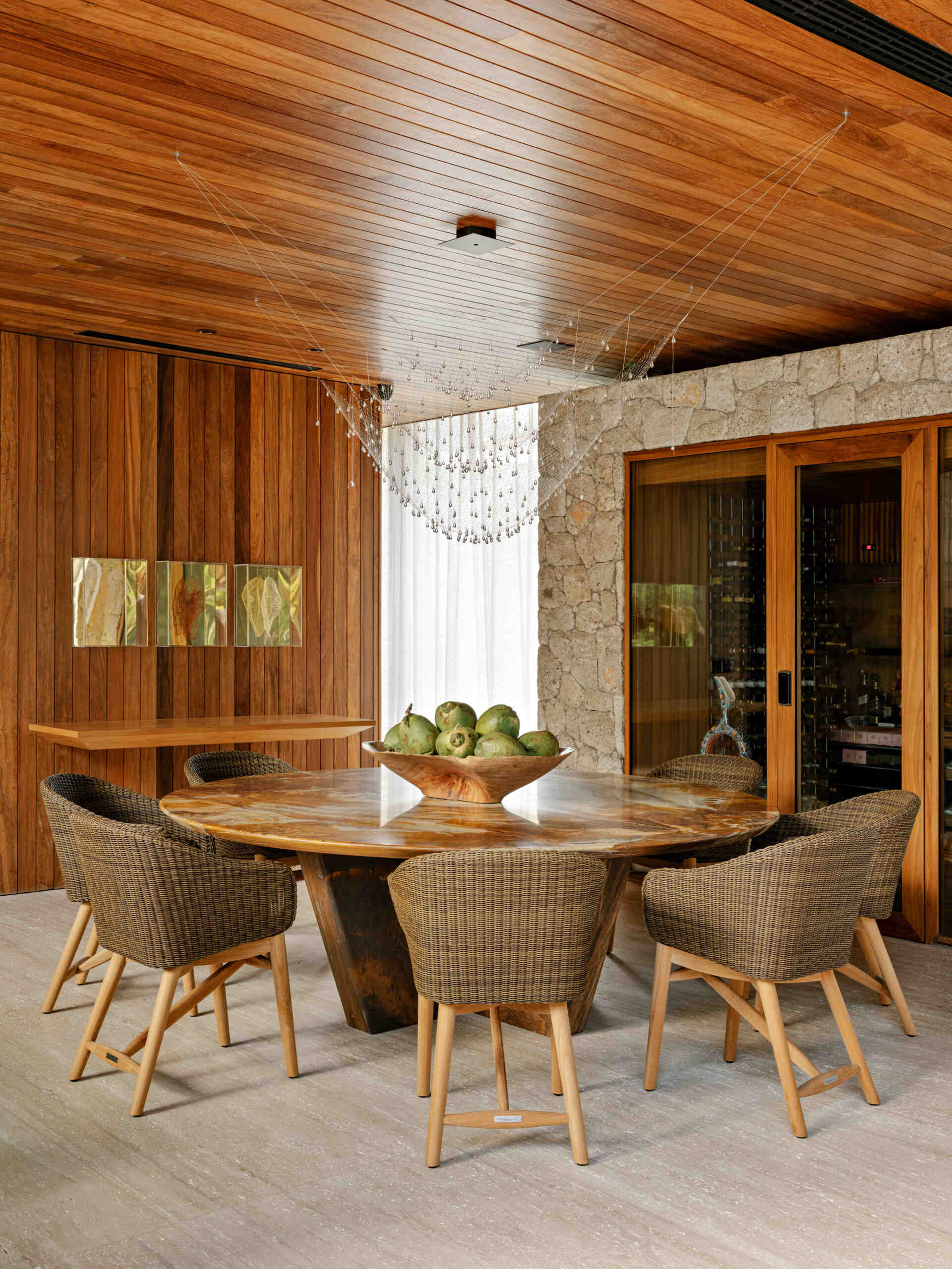 A custom stone dining table and sculptural lighting elevate this elegant coastal dining room.