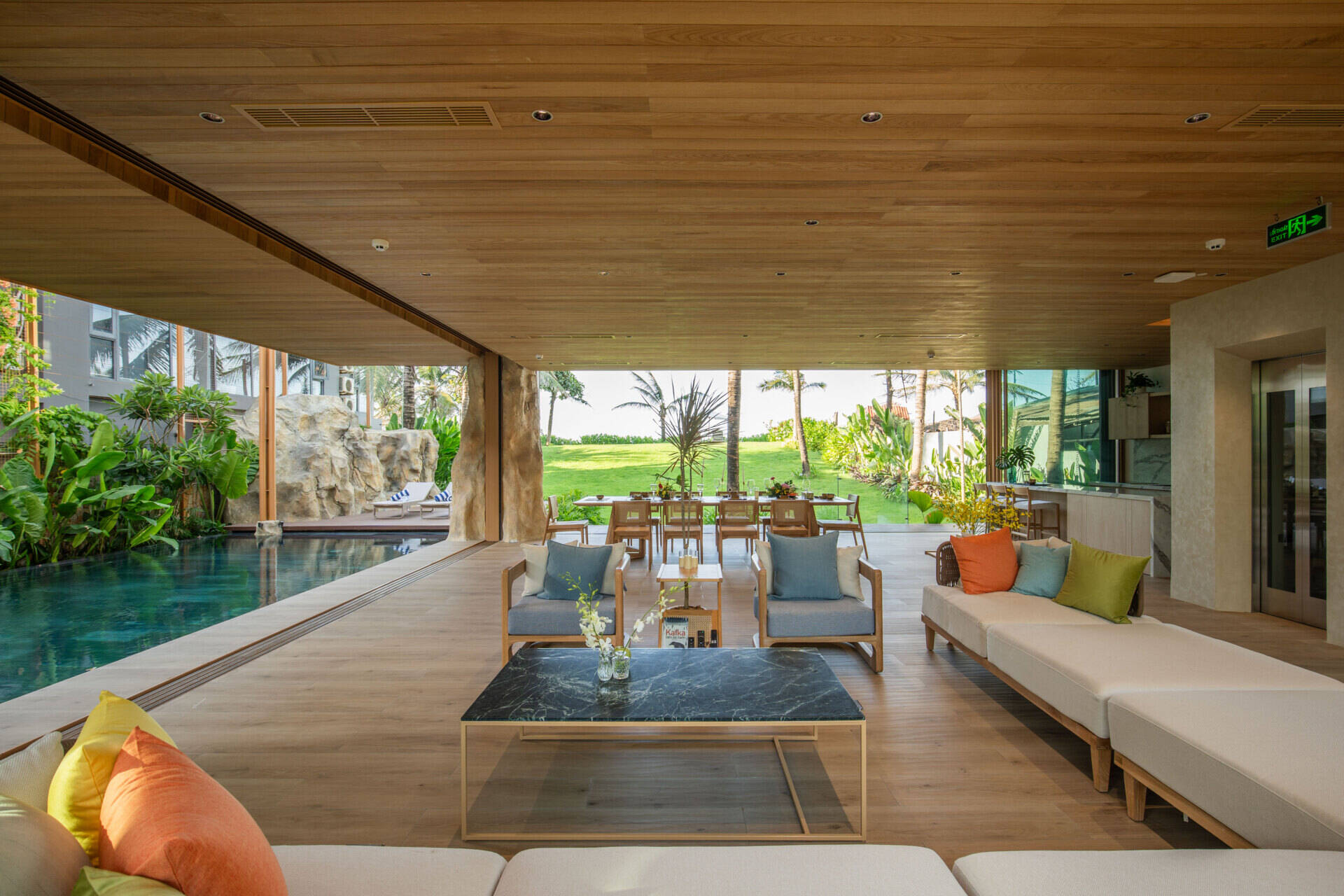 Large sliding glass doors and open-plan living create bright interiors that flow naturally toward the pool, gardens and ocean beyond.