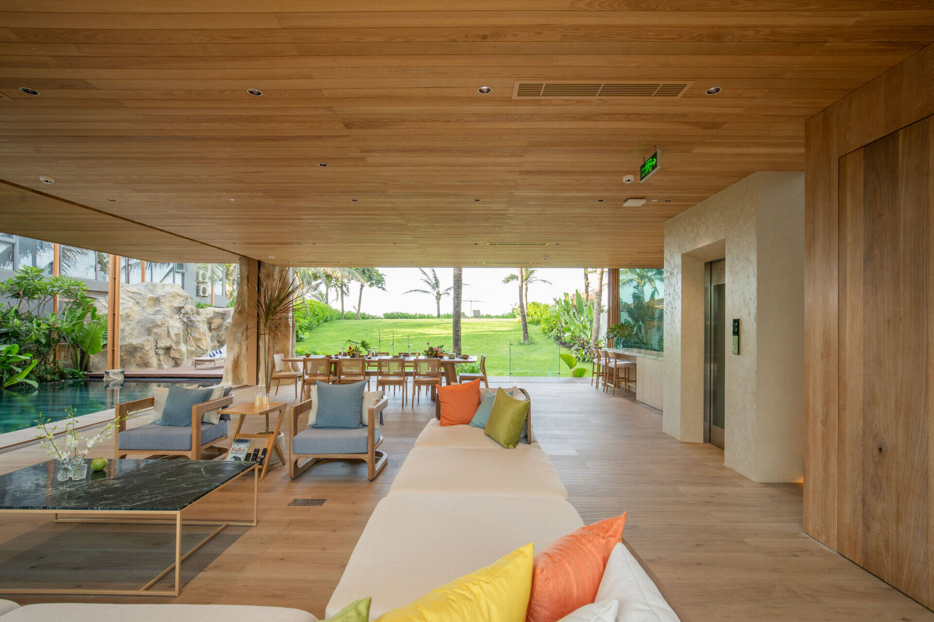 Large sliding glass doors and open-plan living create bright interiors that flow naturally toward the pool, gardens and ocean beyond.