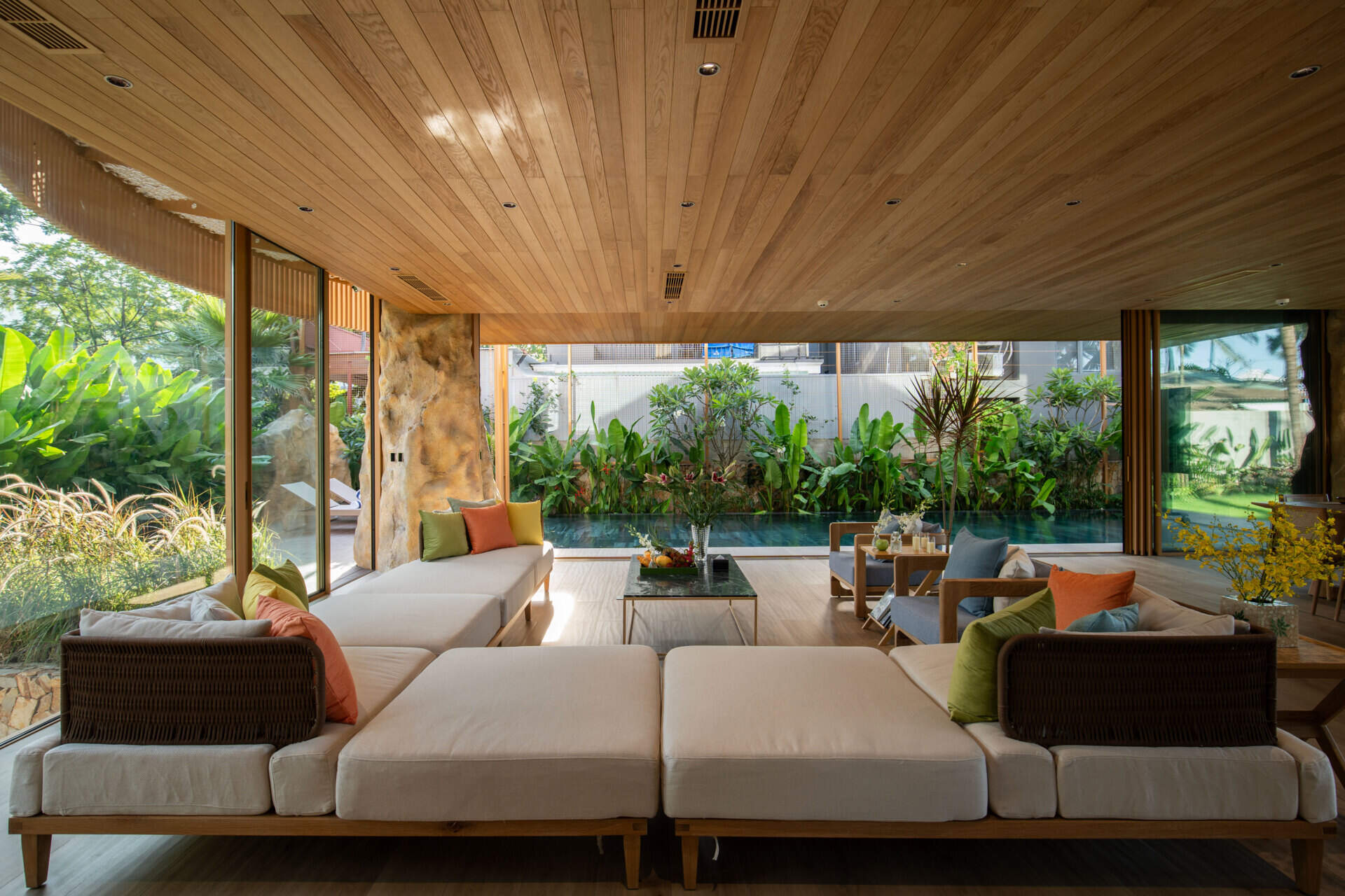 Large sliding glass doors and open-plan living create bright interiors that flow naturally toward the pool, gardens and ocean beyond.