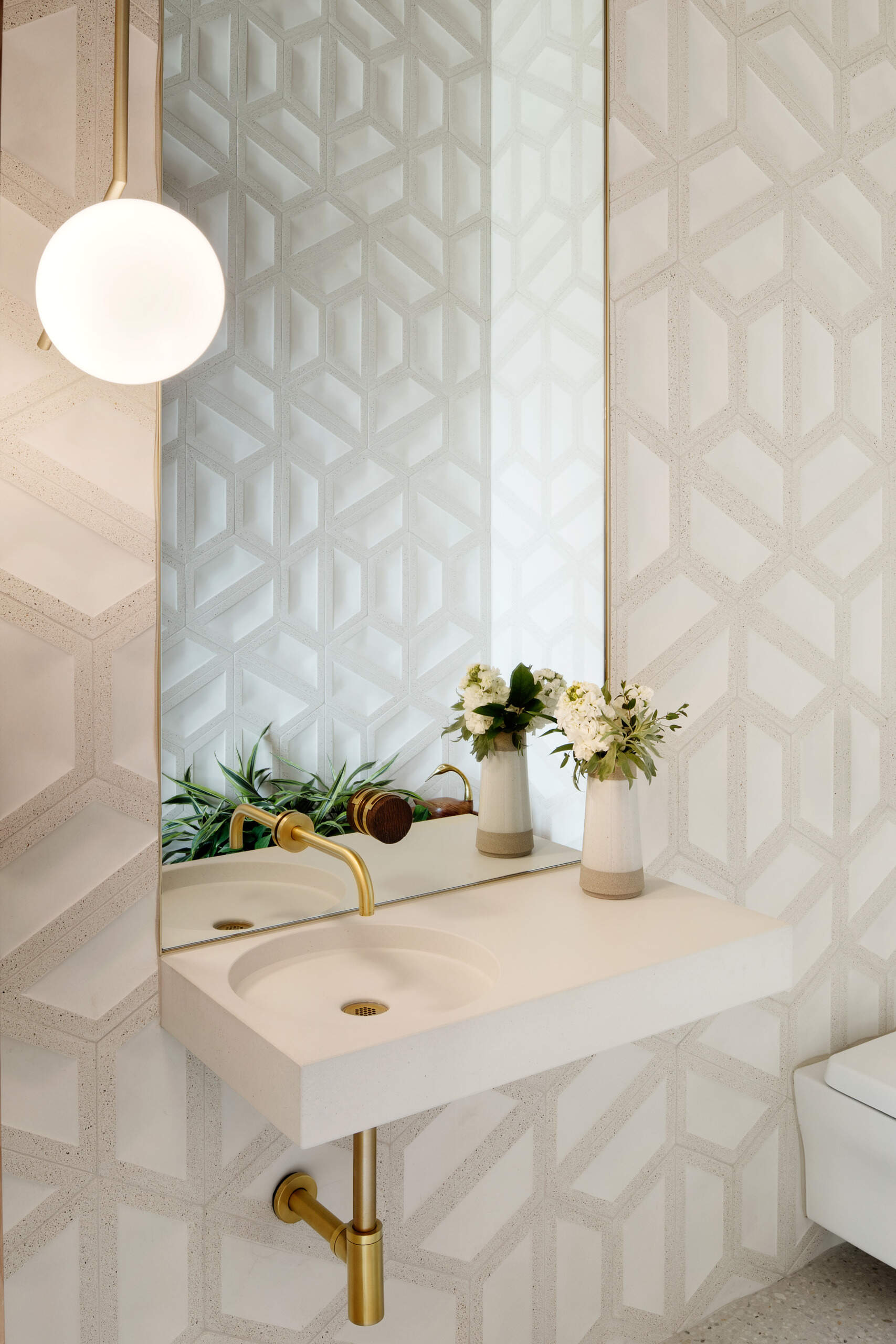 Tocador Vea cómo los azulejos geométricos, los detalles en latón y un lavabo flotante transforman este tocador compacto en una característica de diseño elegante.