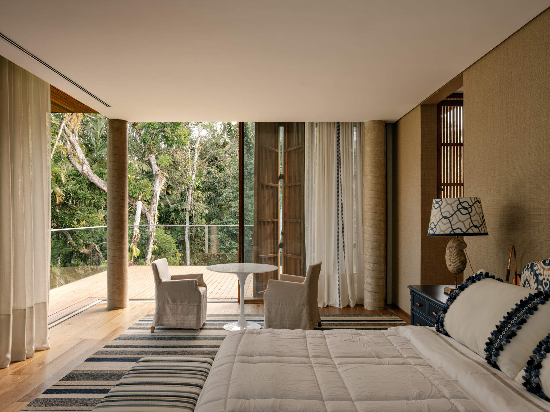 Tour a serene primary suite featuring full-opening windows, natural textures, and peaceful balcony views.