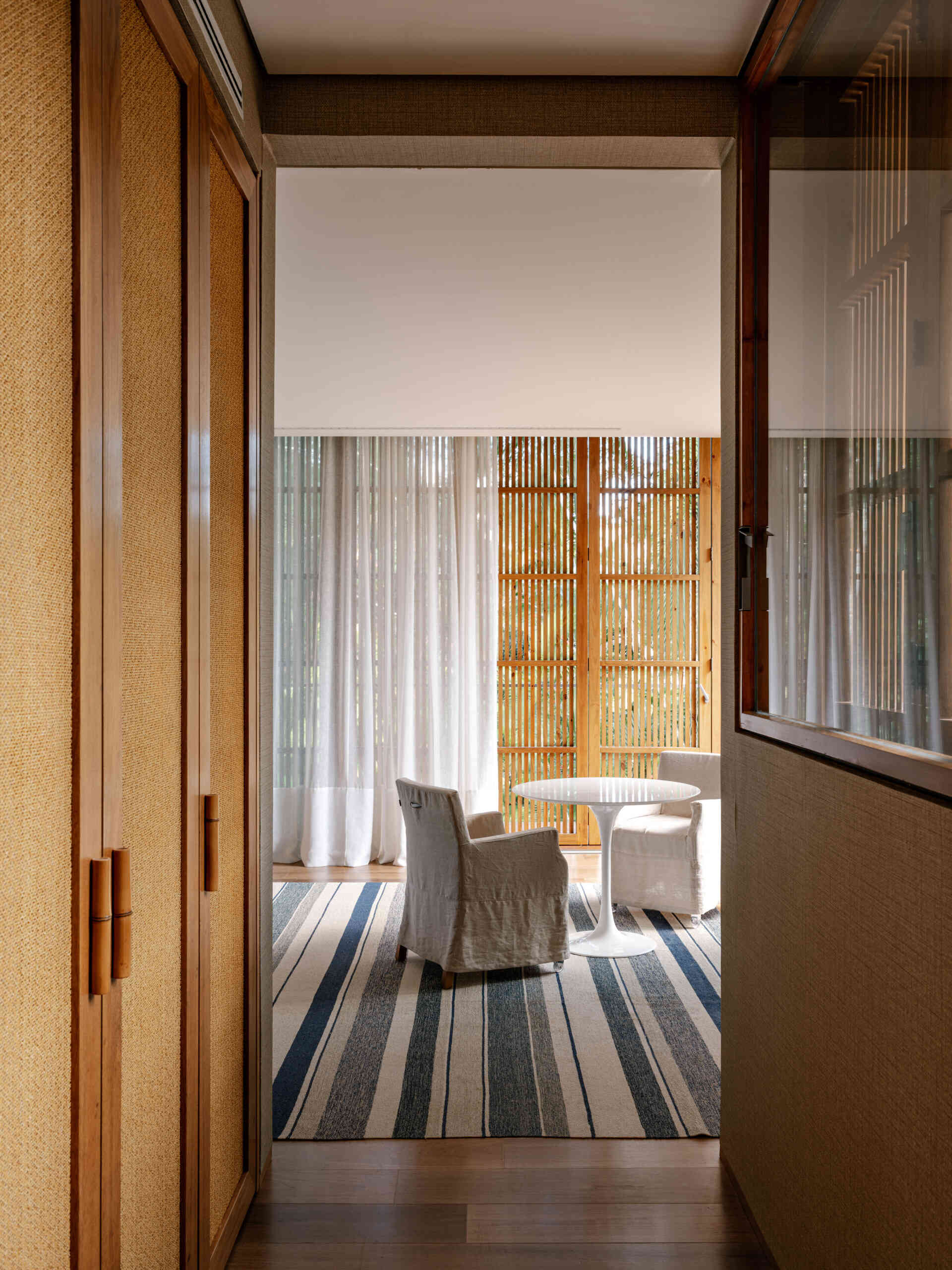 Tour a serene primary suite featuring full-opening windows, natural textures, and peaceful balcony views.