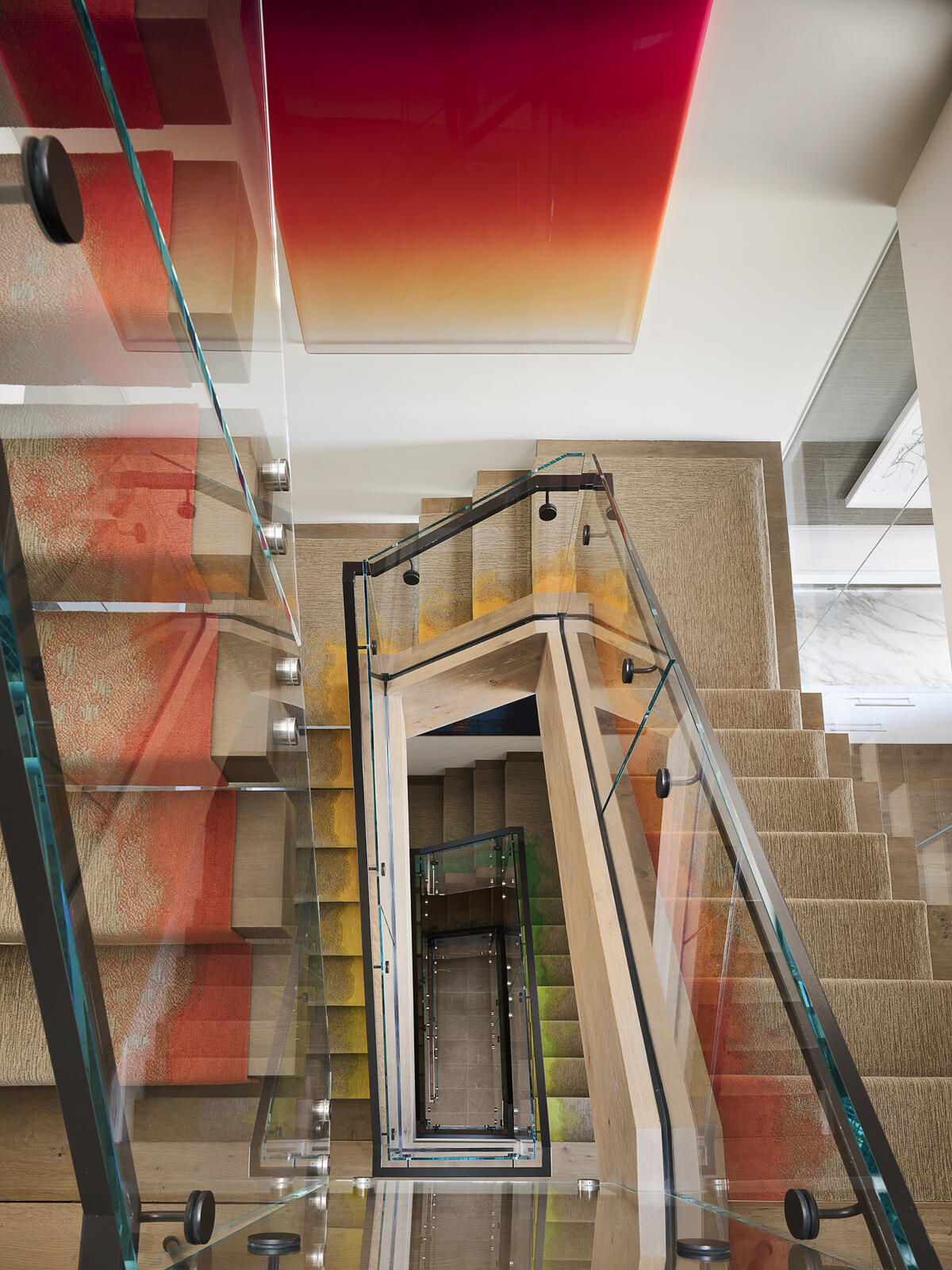 A vibrant stair runner transforms this staircase into the defining feature of the home, weaving a spectrum of color through every level. Paired with contemporary artwork, it creates a bold visual thread that connects the entire interior while turning a functional space into a striking design statement.