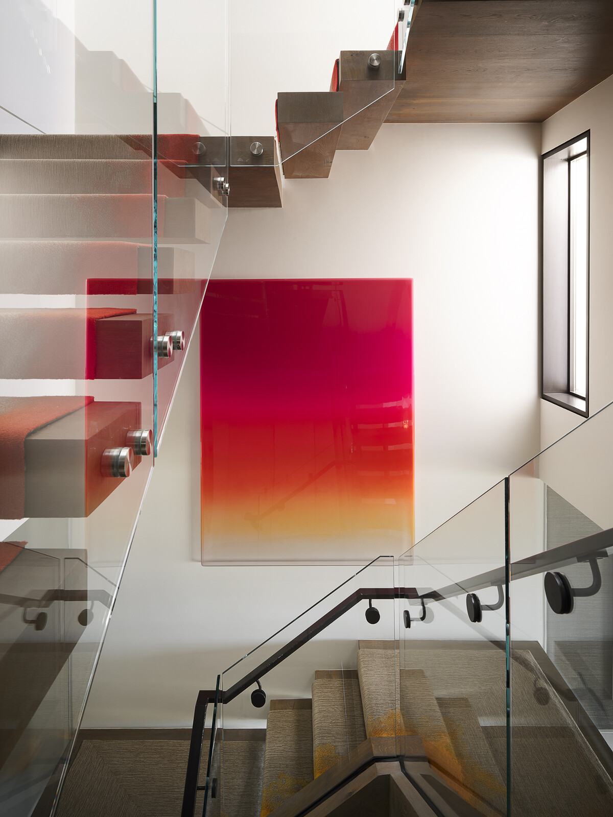 A vibrant stair runner transforms this staircase into the defining feature of the home, weaving a spectrum of color through every level. Paired with contemporary artwork, it creates a bold visual thread that connects the entire interior while turning a functional space into a striking design statement.