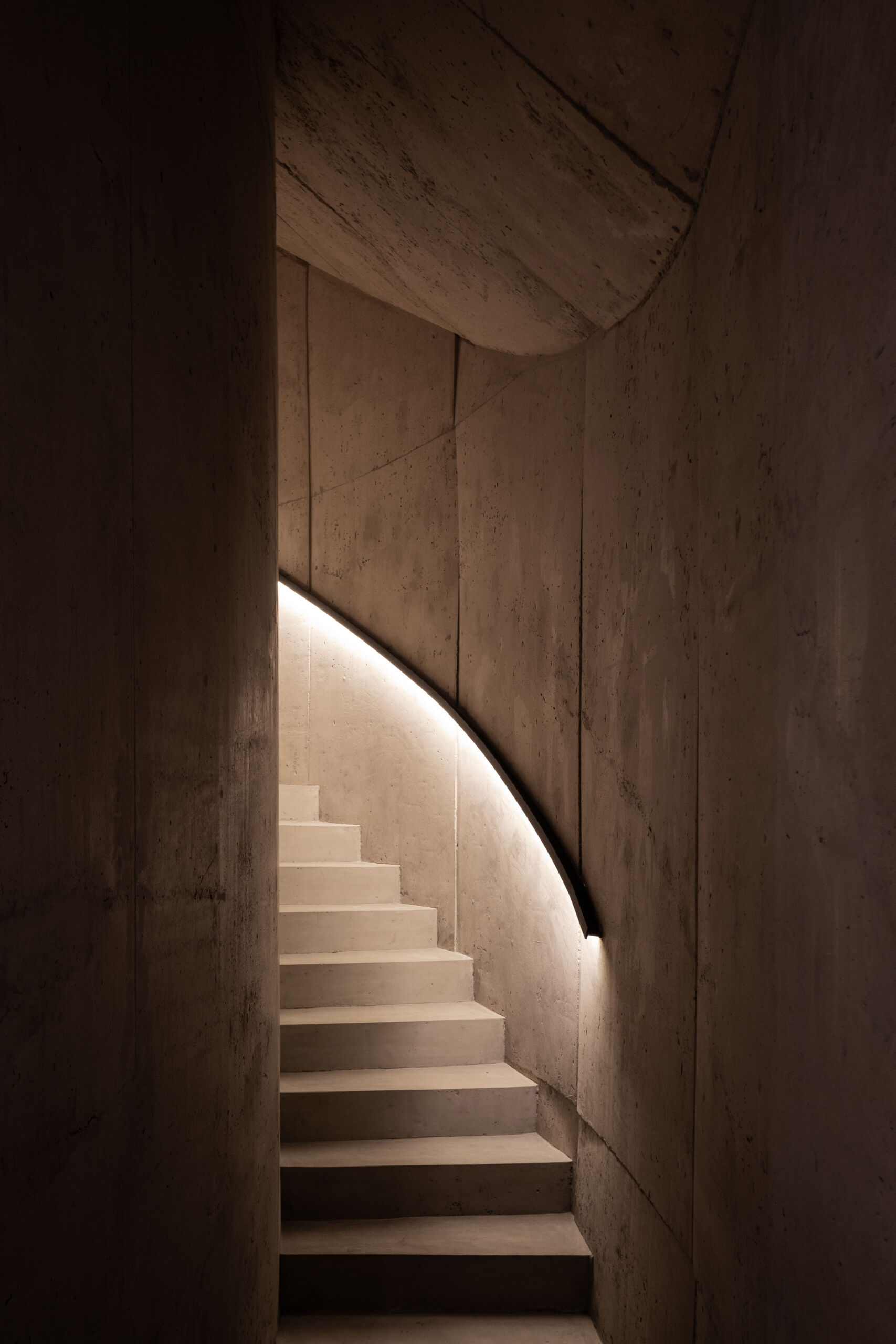 See how an interior concrete staircase with hidden lighting creates a smooth connection between floors.