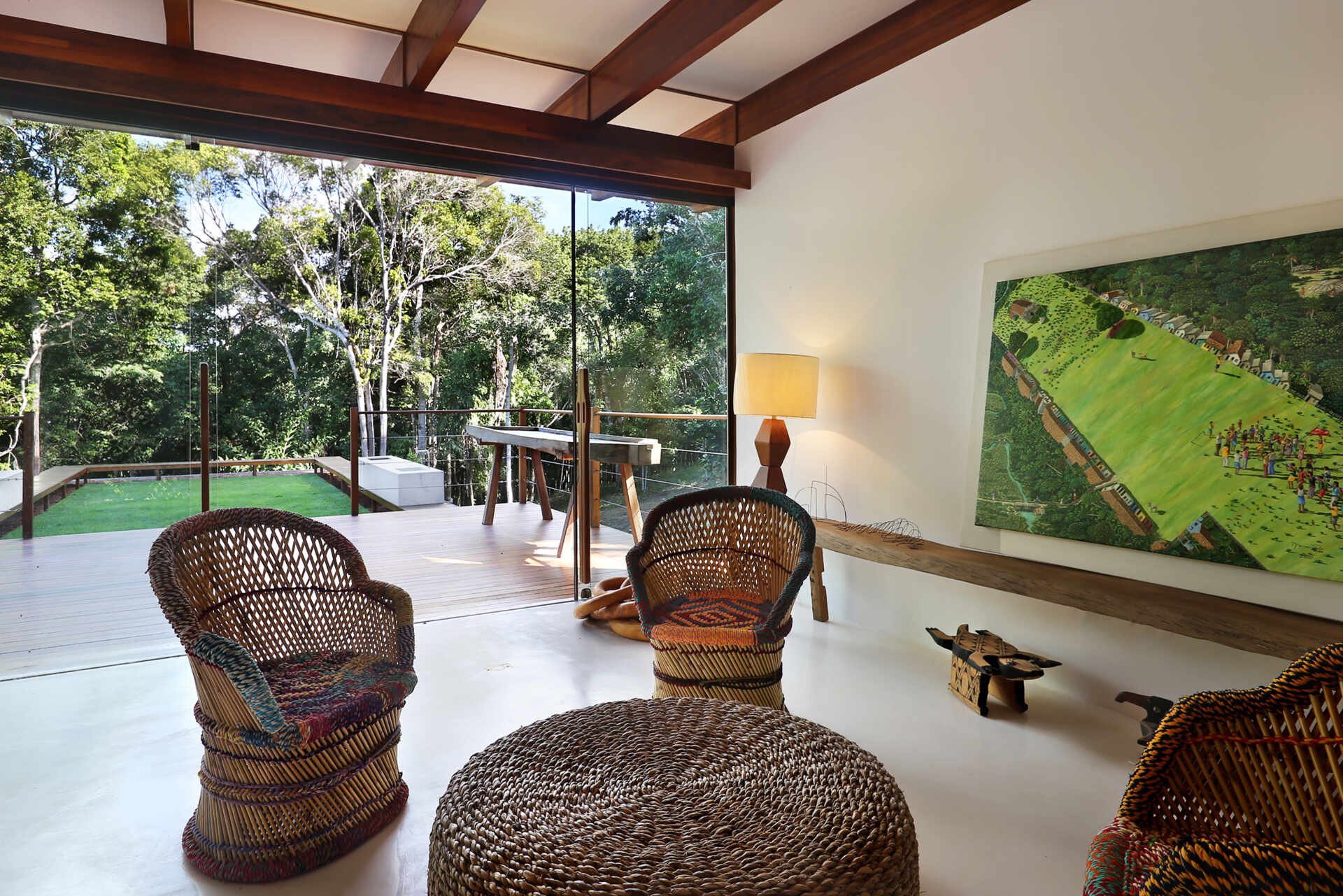 Inside, a 78 foot (24-metre) open-plan living space combines custom furniture, artisan lighting and seamless white cement floors beneath exposed timber beams.
