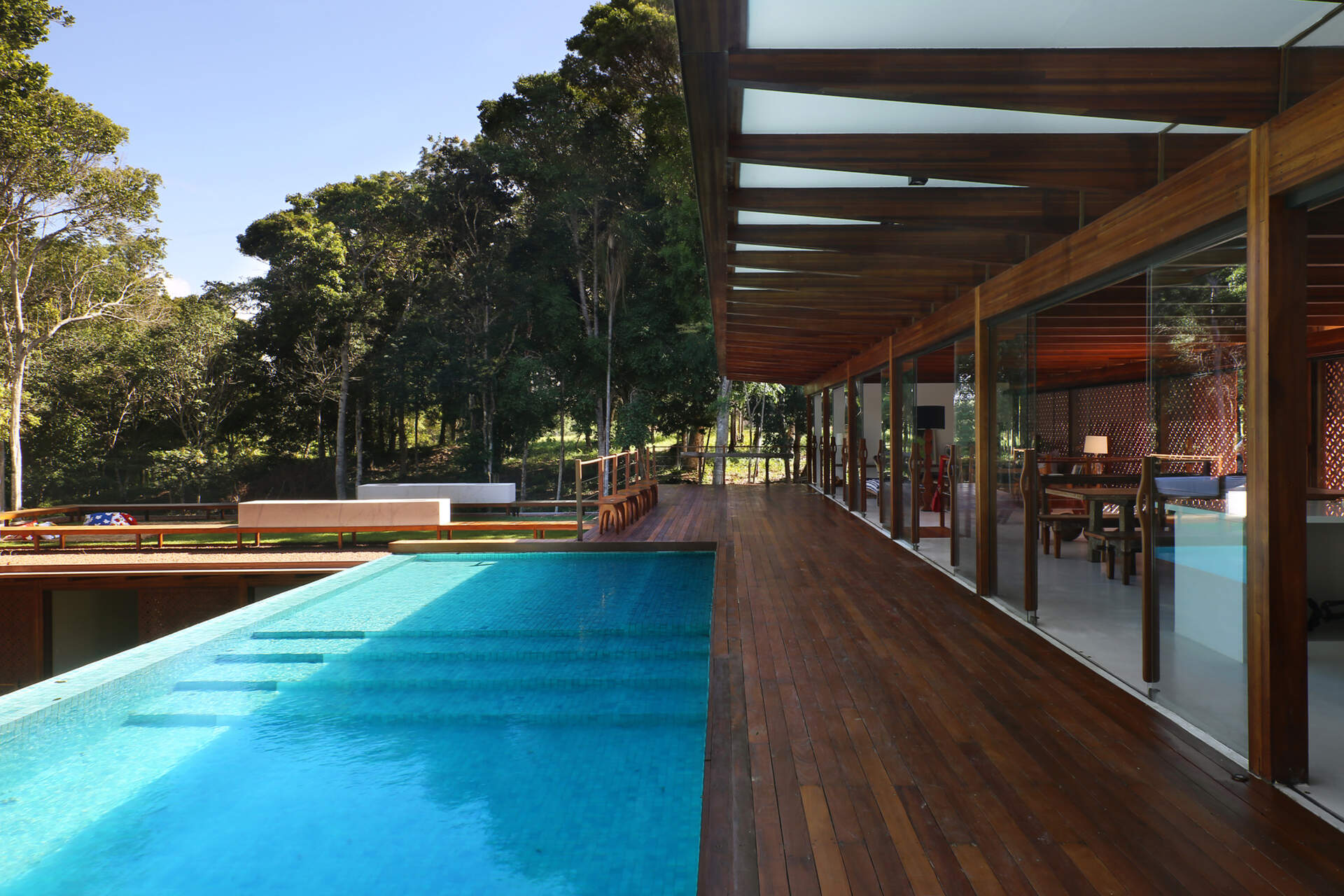 An infinity pool floats above the Atlantic Forest while a generous timber deck and wraparound bench create the perfect outdoor entertaining space.