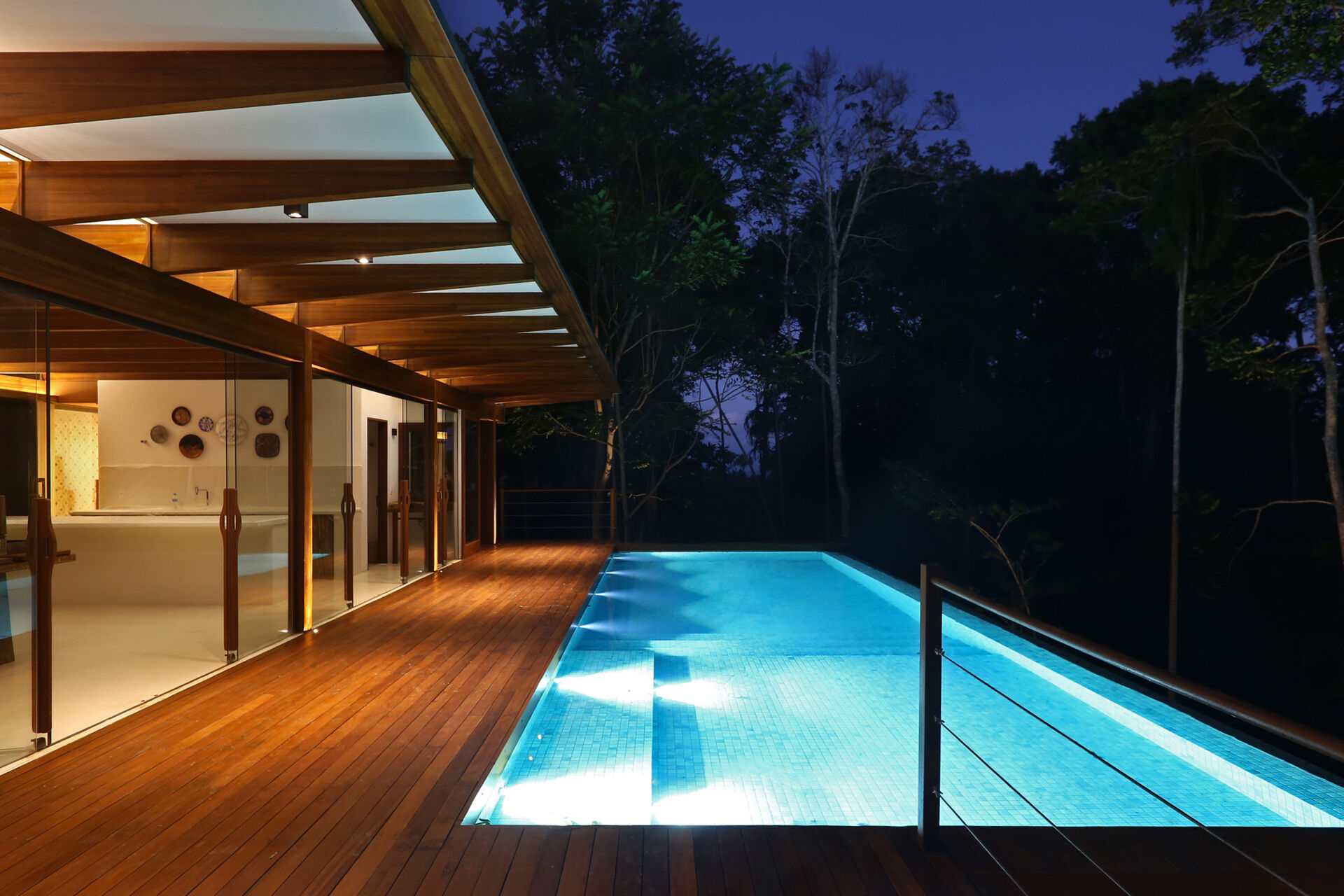 An infinity pool floats above the Atlantic Forest while a generous timber deck and wraparound bench create the perfect outdoor entertaining space.