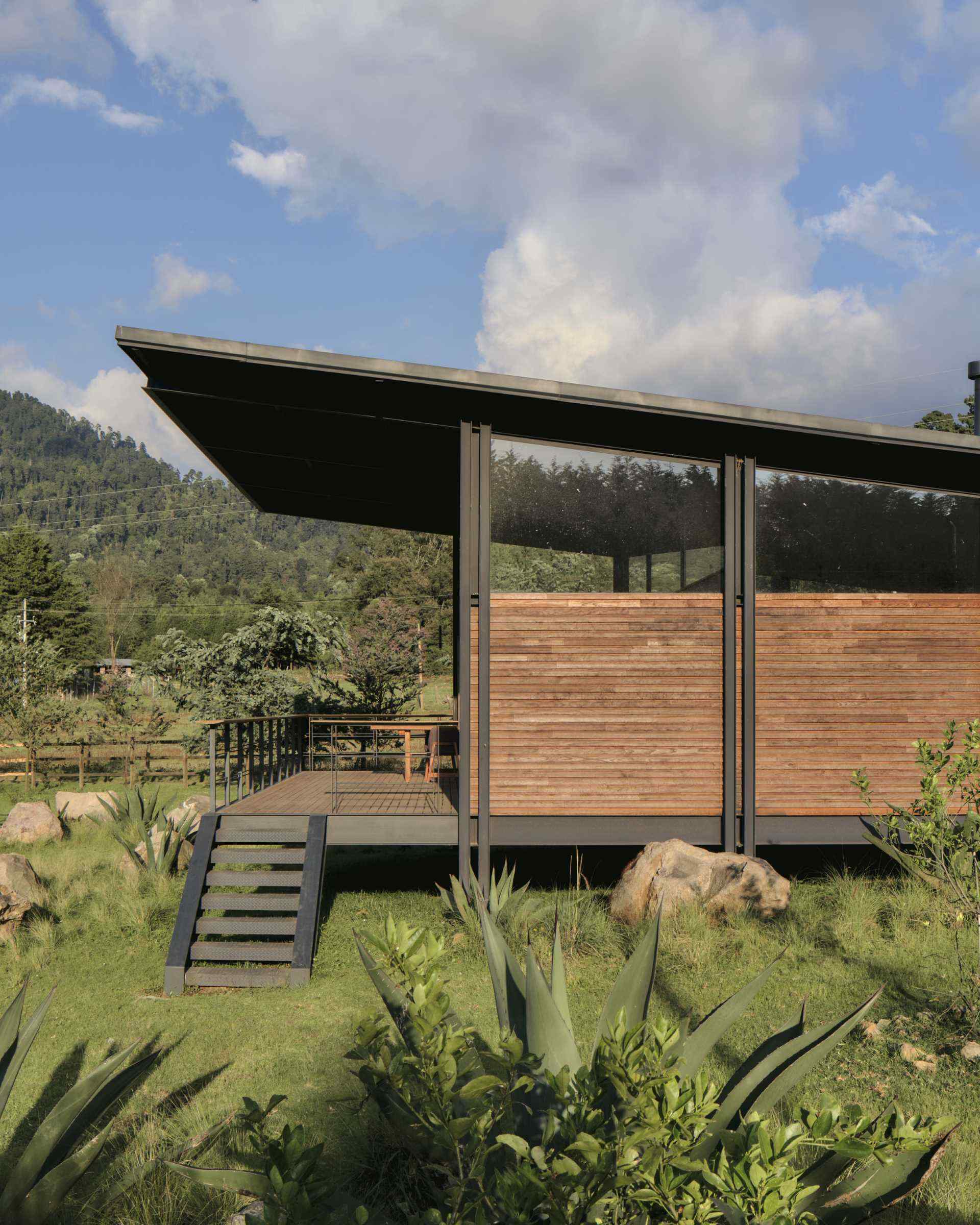Heat-treated timber, steel and glass come together in this tiny house, creating a warm exterior that also improves thermal performance.