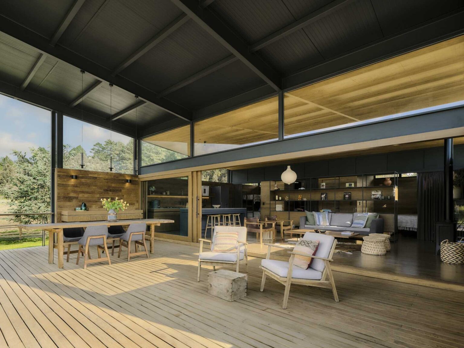 See how a sloping roof creates a dramatic double-height terrace that opens this tiny house towards the surrounding forest.