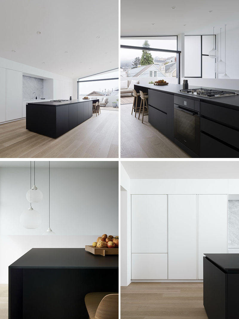 Explore a minimalist kitchen with a bold black island, hidden powder room, timber seating steps, and clever modern details.