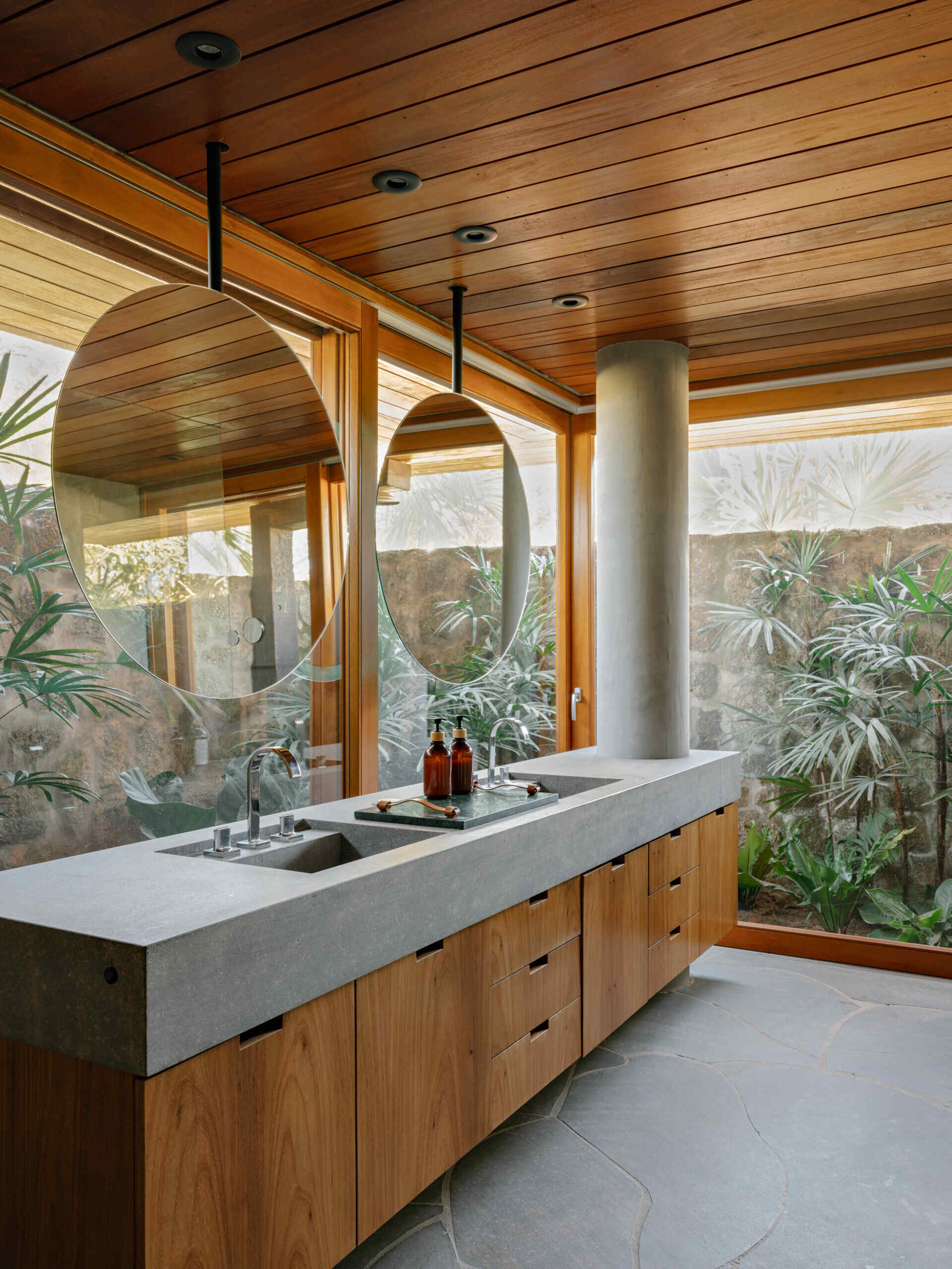 This bathroom carries the same combination of wood, stone and neutral finishes used throughout the rest of the home, creating visual consistency from room to room. Natural materials remain the focus, giving these everyday spaces the same welcoming character found across the larger living areas.